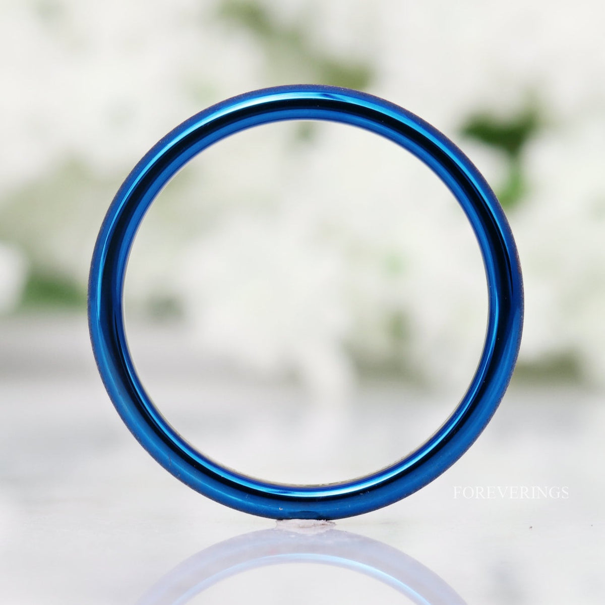 Sandblasted blue tungsten band standing face-on, showing its thin 2mm profile