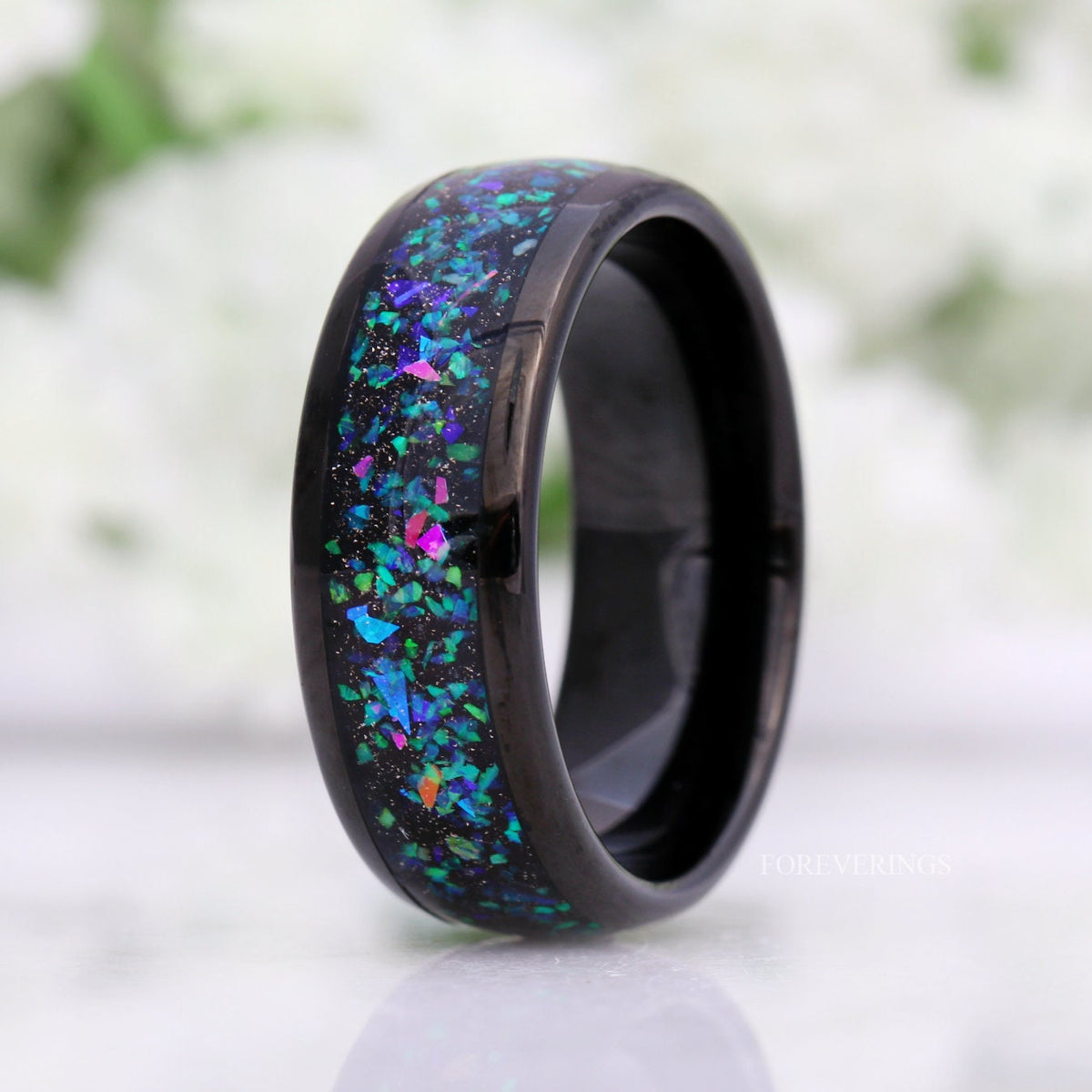 Men's 8mm black tungsten ring with galaxy opal inlay standing at an angle, polished dome