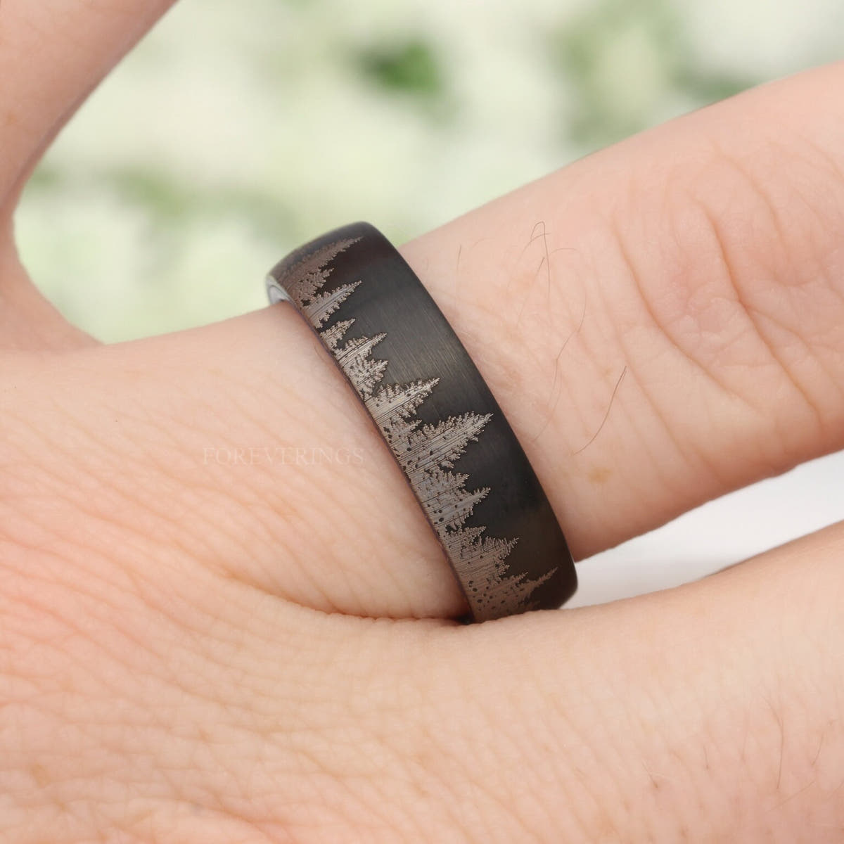 Brushed black tungsten tree line band on a hand, side view