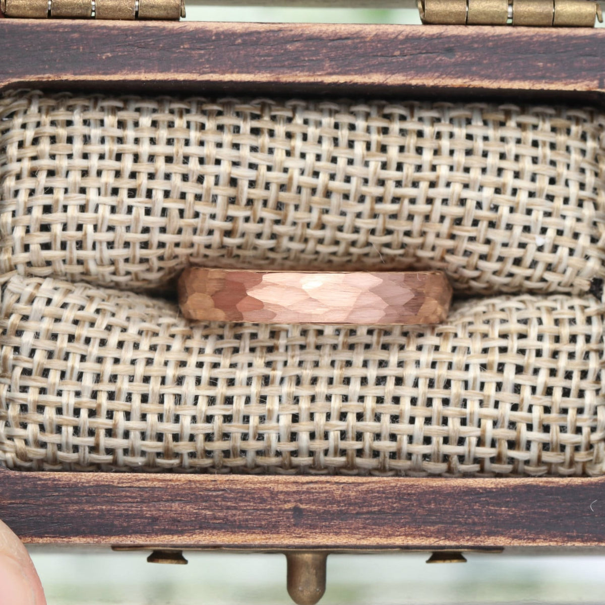 4mm hammered rose gold band in a wood ring box, close crop