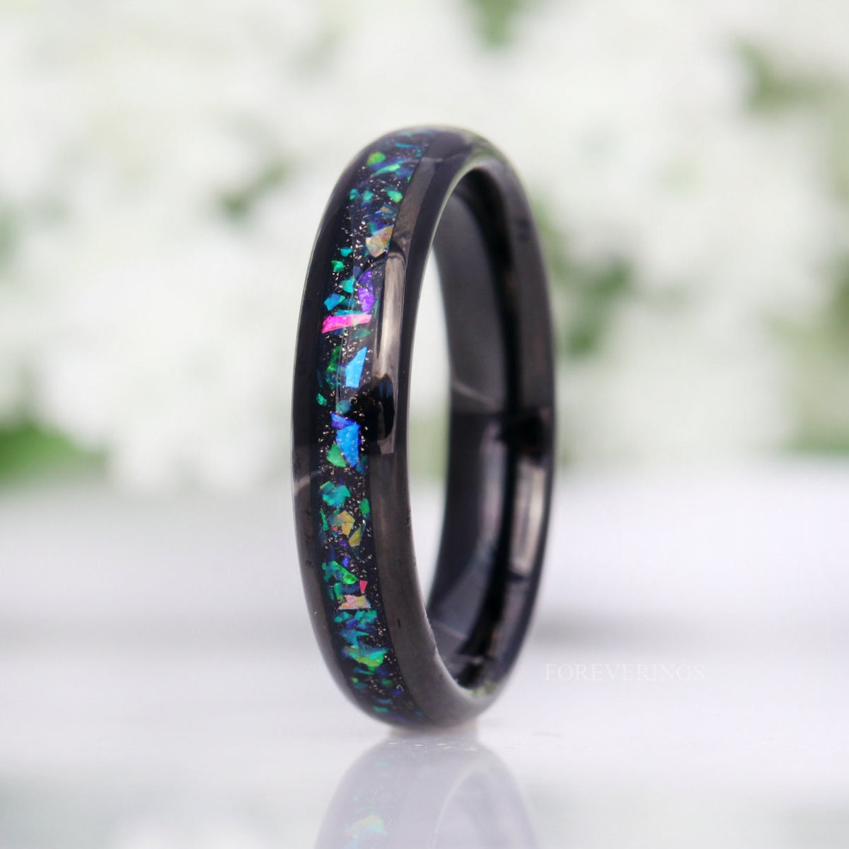 Women's 4mm black tungsten ring with galaxy opal inlay, standing upright