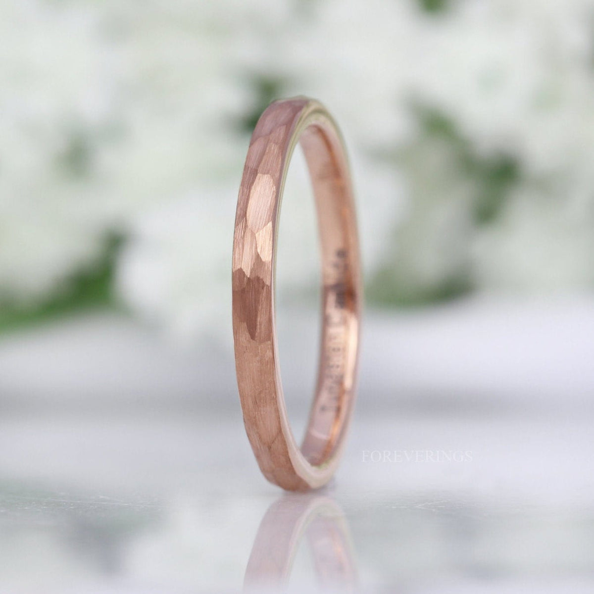 2mm hammered rose gold tungsten band standing on edge, matte faceted finish