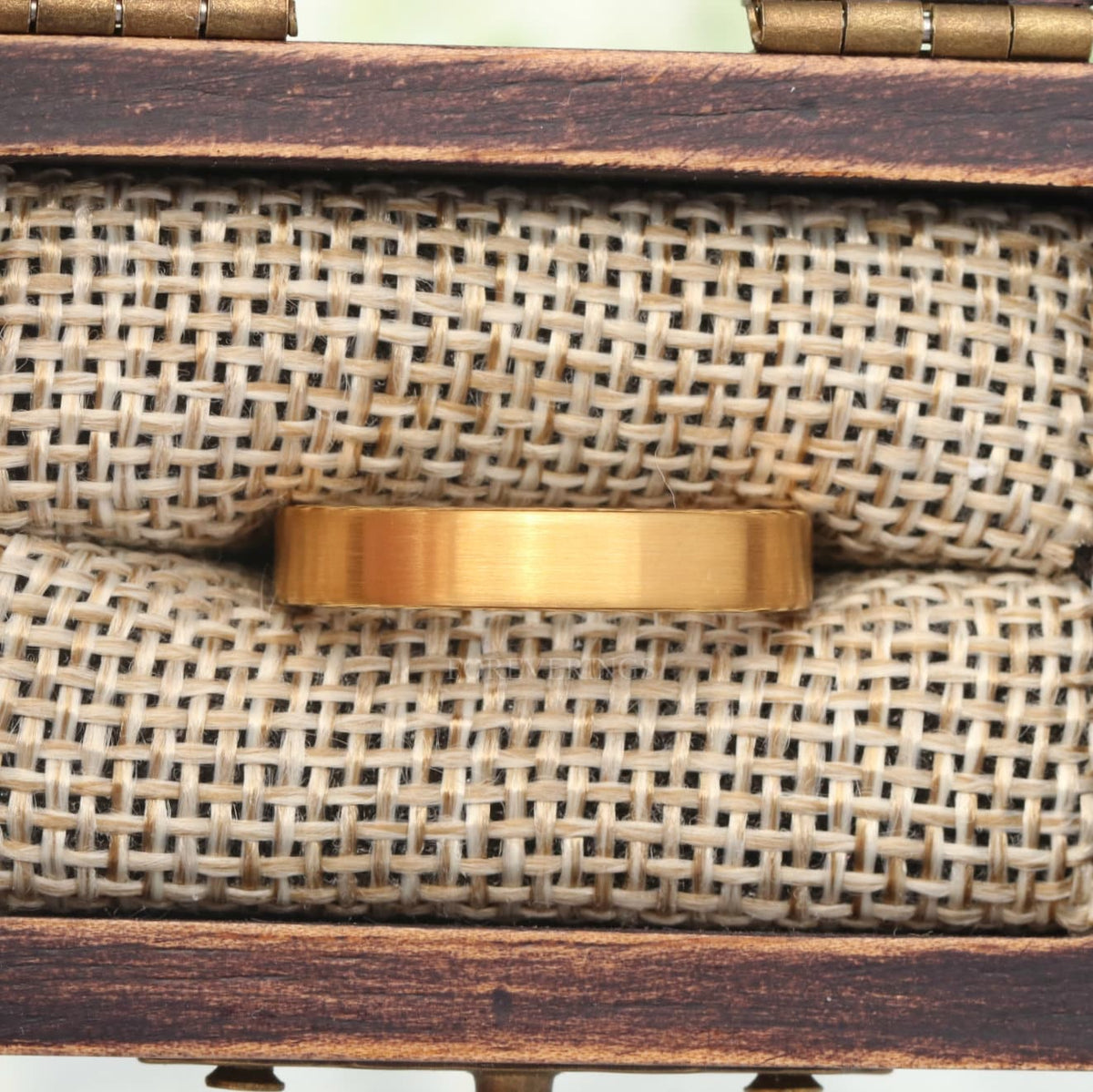 4mm matte gold tungsten band in a wood ring box, close crop