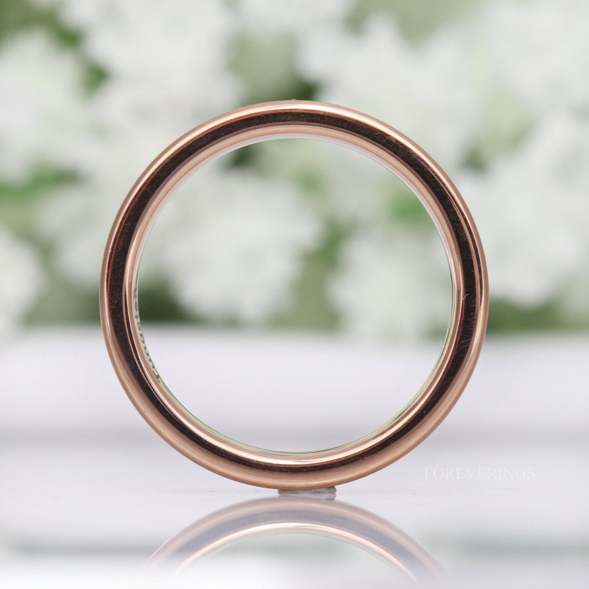 4mm matte rose gold tungsten band seen straight on through the circle, reflection below
