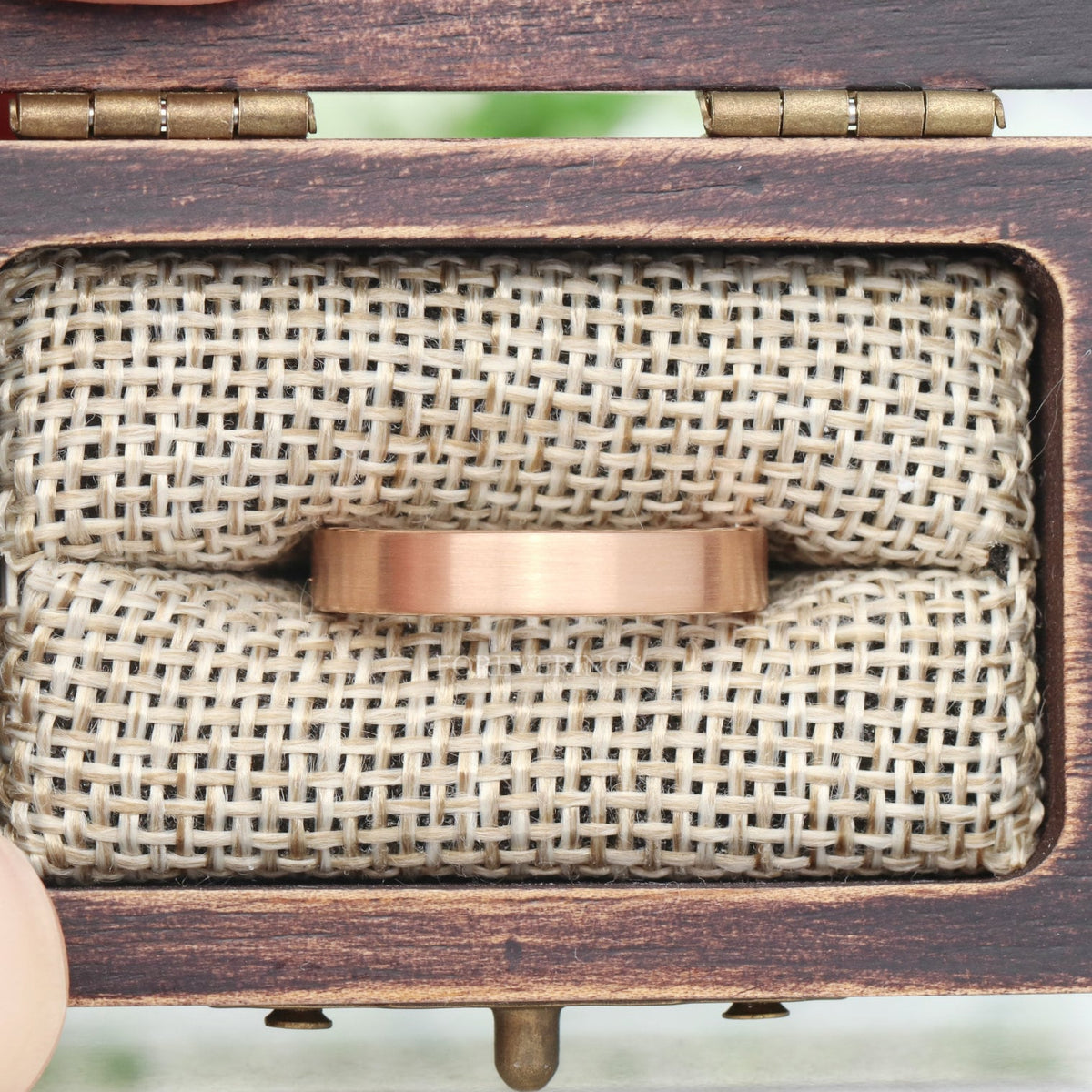 4mm matte rose gold tungsten band set in a wooden ring box on a burlap cushion