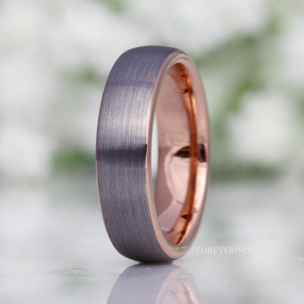 Men's 6mm brushed silver tungsten band with a rose gold interior, standing at an angle