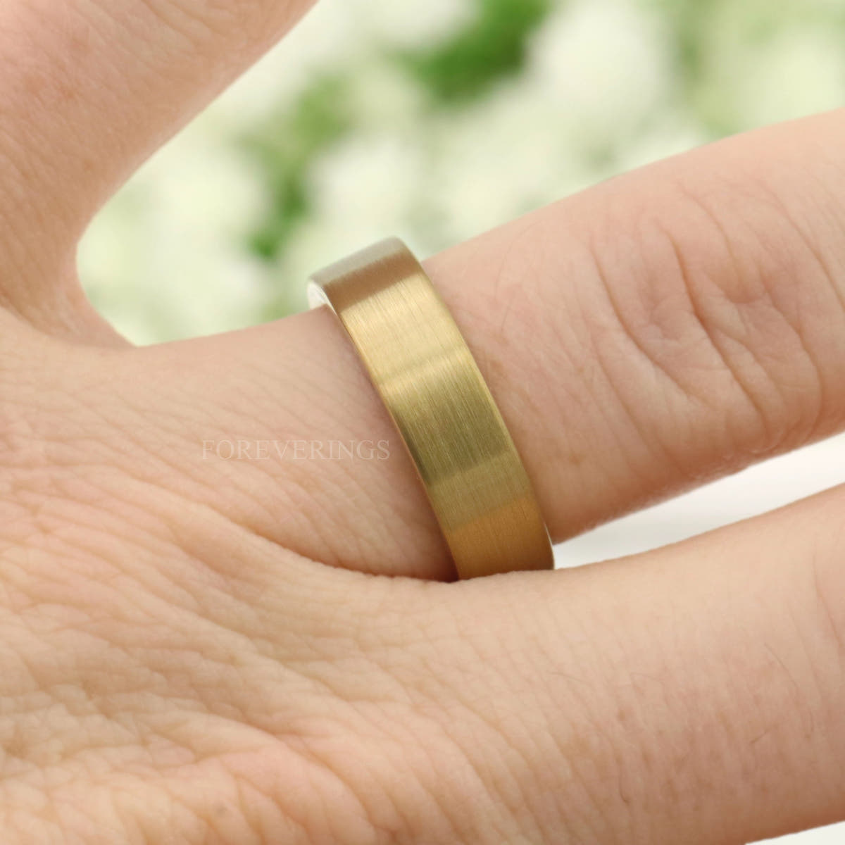 Men's 6mm matte gold tungsten band worn on a finger