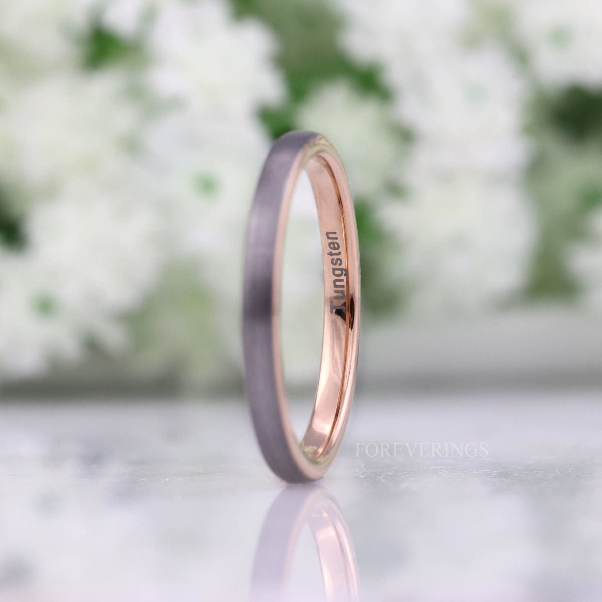 Her 2mm brushed silver tungsten band with rose gold interior, standing at an angle