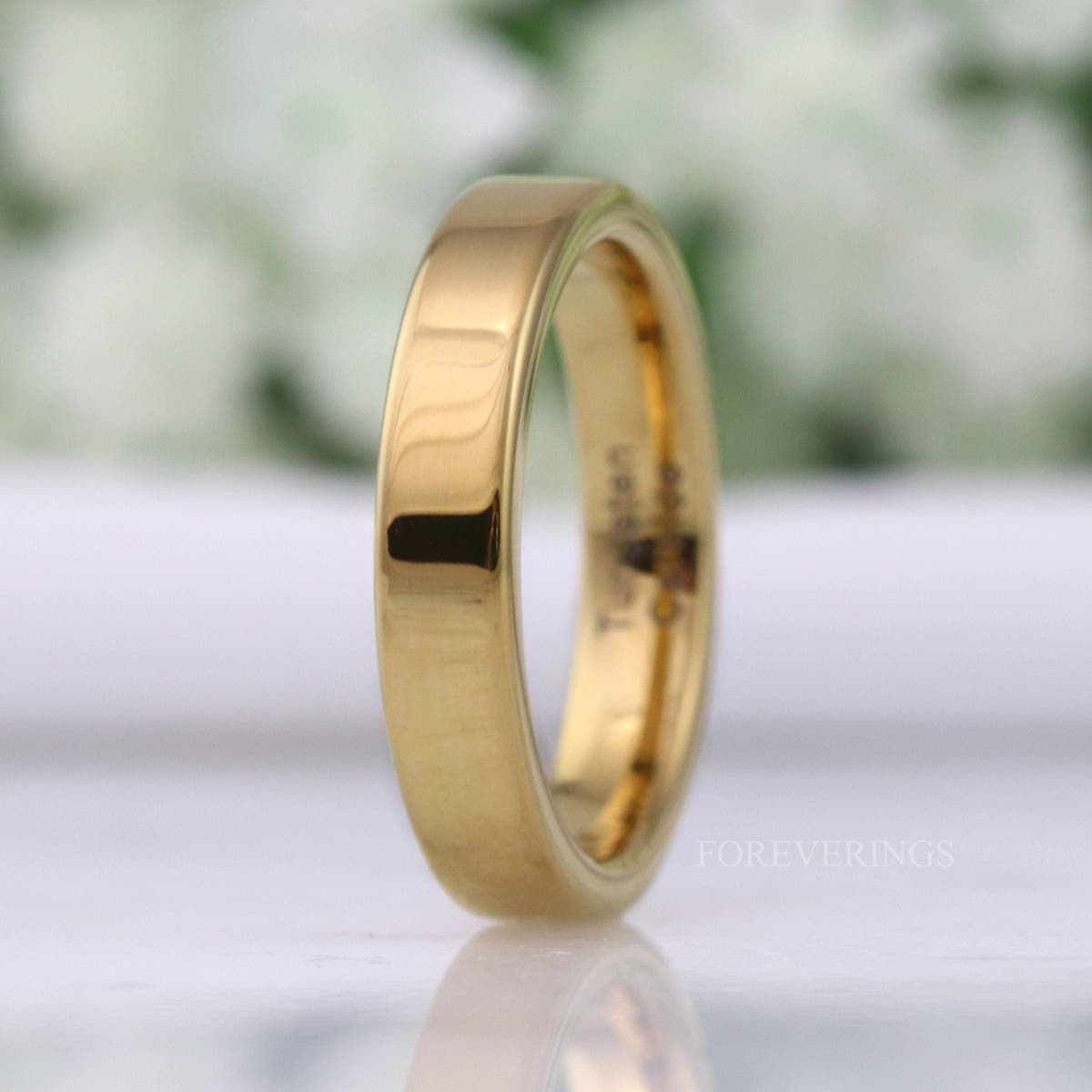4mm polished gold tungsten band standing upright, turned more face-on to show the mirror-bright surface