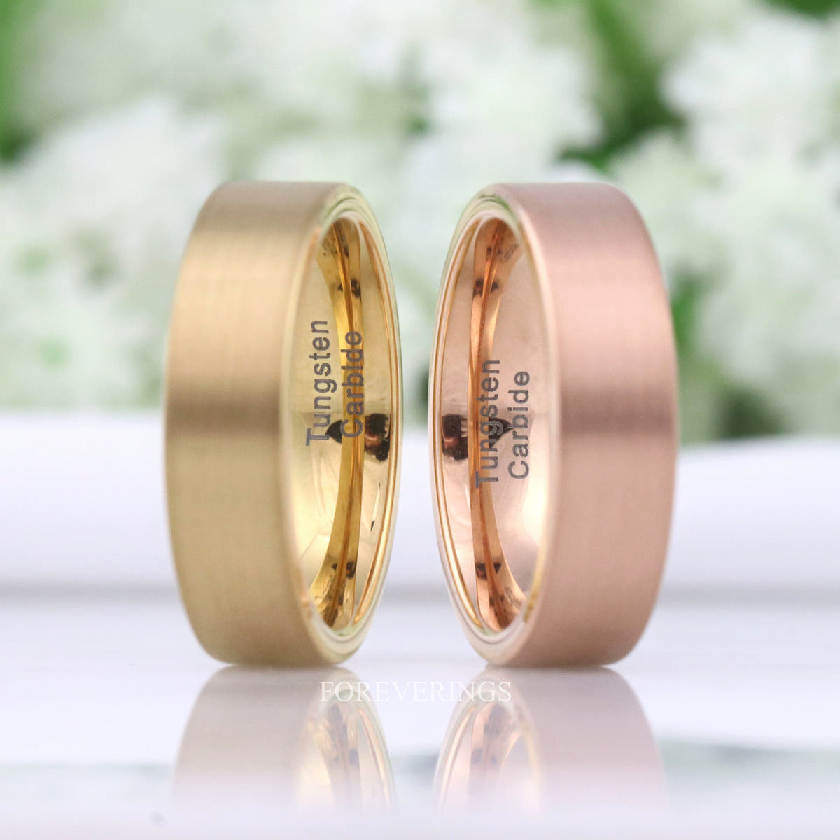 Gold and rose gold brushed tungsten bands side by side, turned to show the inside
