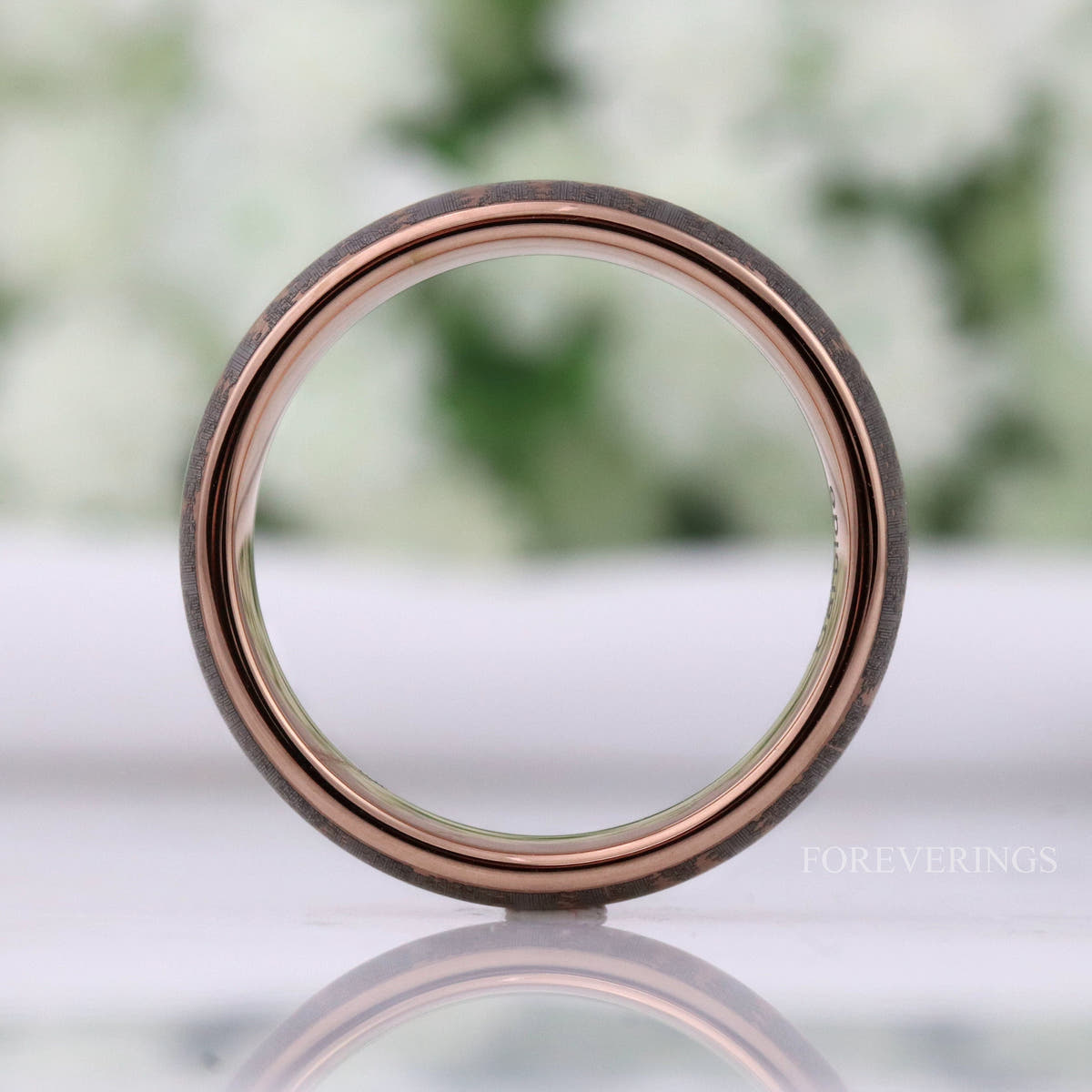 Rose gold tungsten forest band viewed through the center, gray etched edge visible