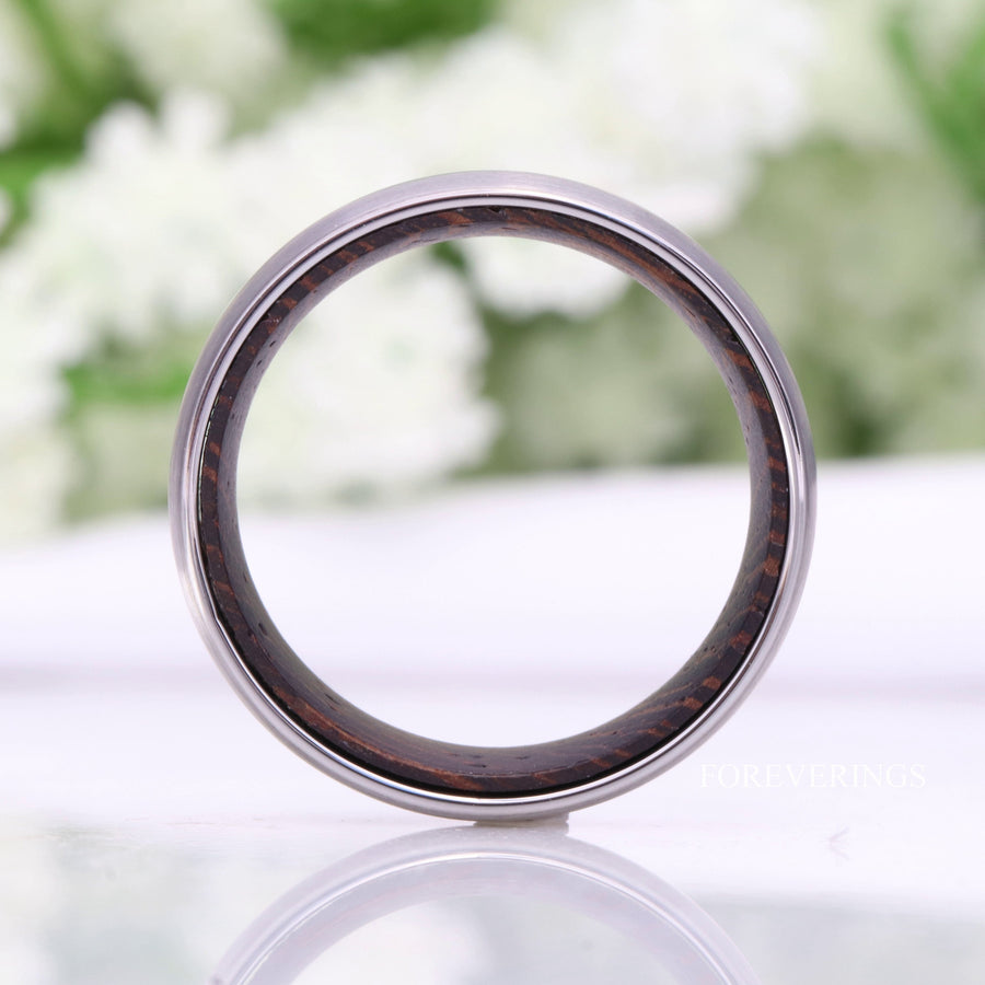 Silver tungsten band viewed straight through the center to show the dark wood lining