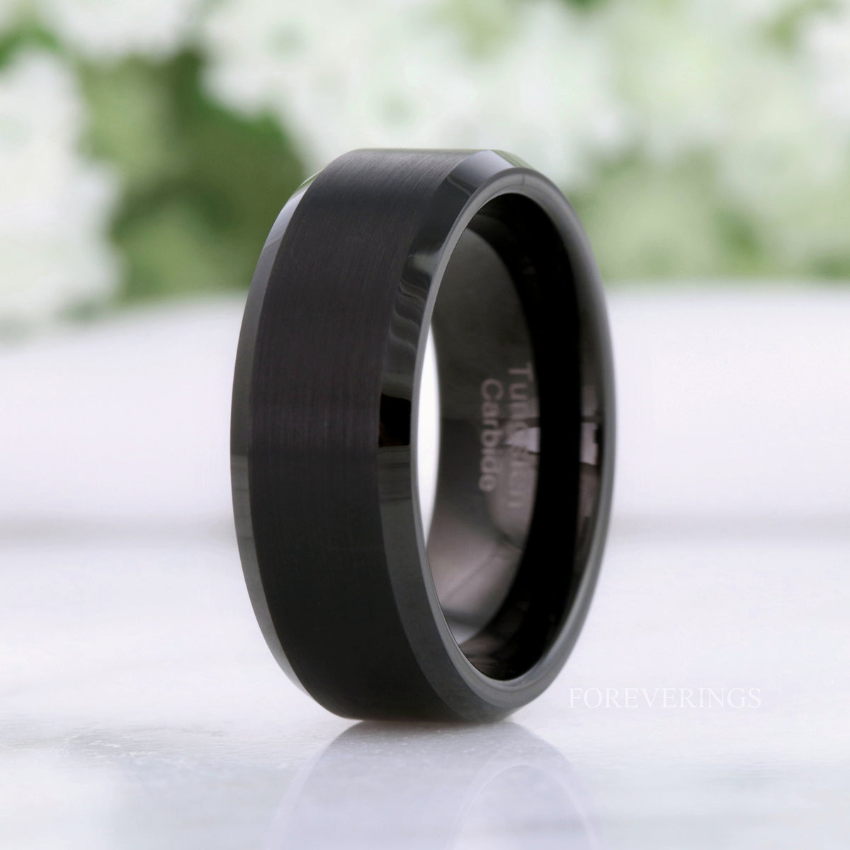 Men's 8mm matte black tungsten band with beveled edges, standing at an angle