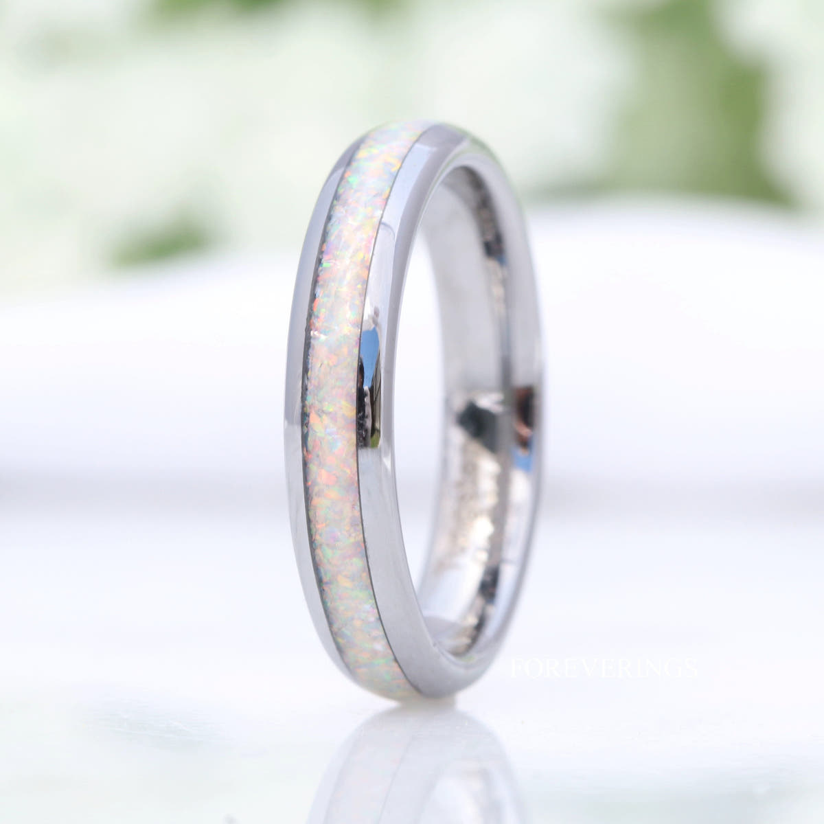 4mm silver tungsten white opal ring standing upright, straight side view