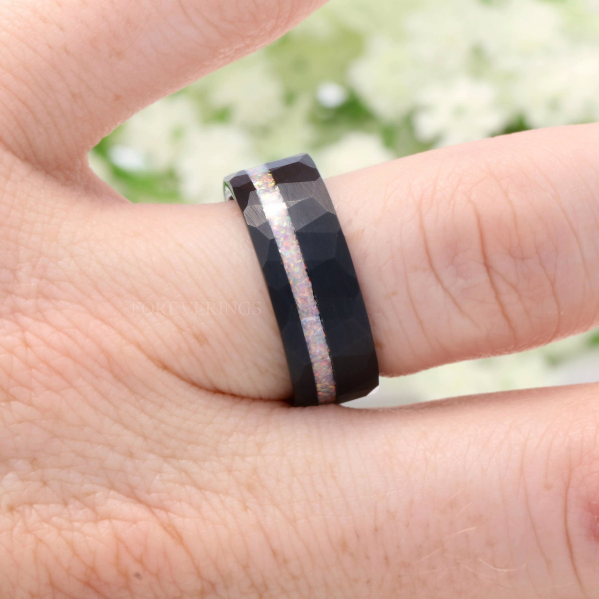 8mm black hammered tungsten band with a white fire opal stripe worn on a finger