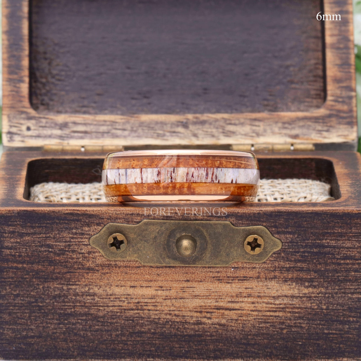 6mm rose gold tungsten whiskey barrel and antler band in an open rustic wood ring box, straight on
