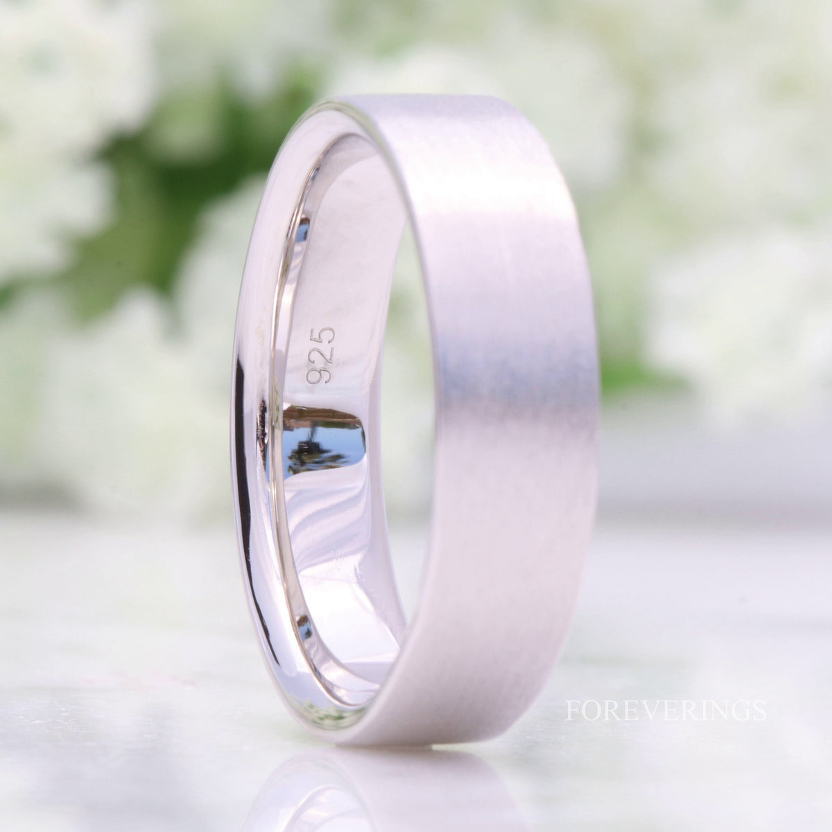 Flat 6mm sterling silver band standing upright, angled to show the polished interior