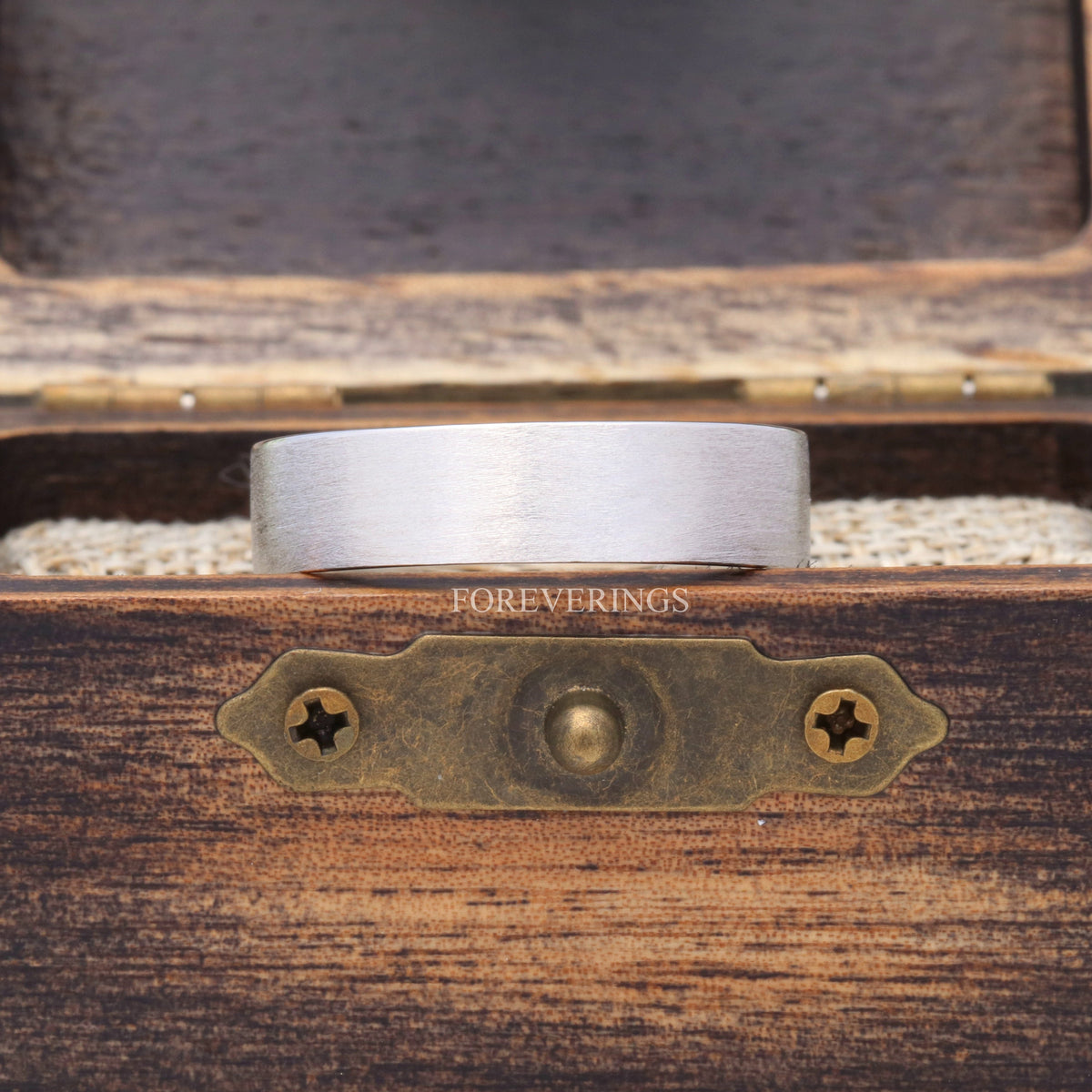 Brushed sterling silver band in a rustic wood ring box