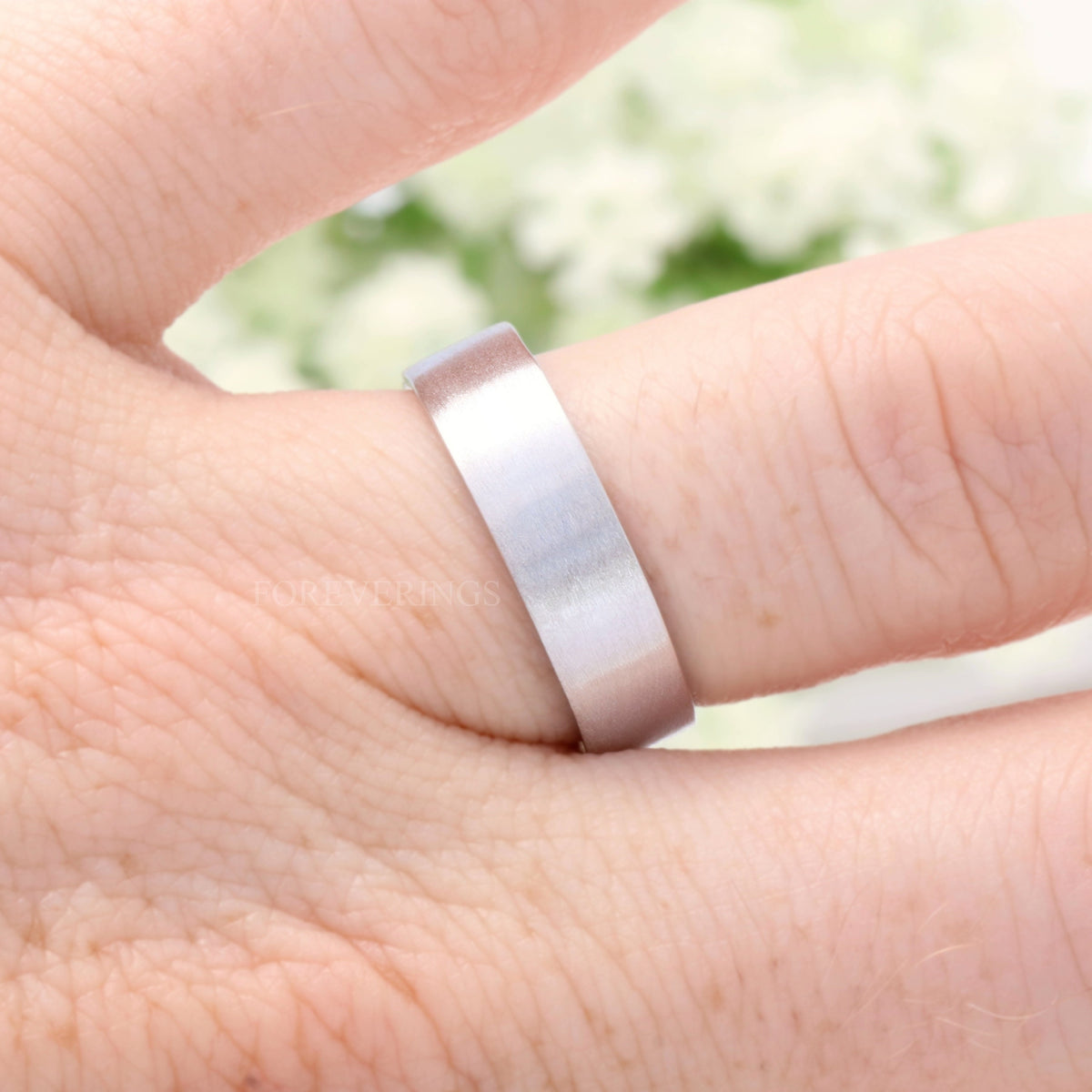 6mm brushed sterling silver band on a finger, close side view
