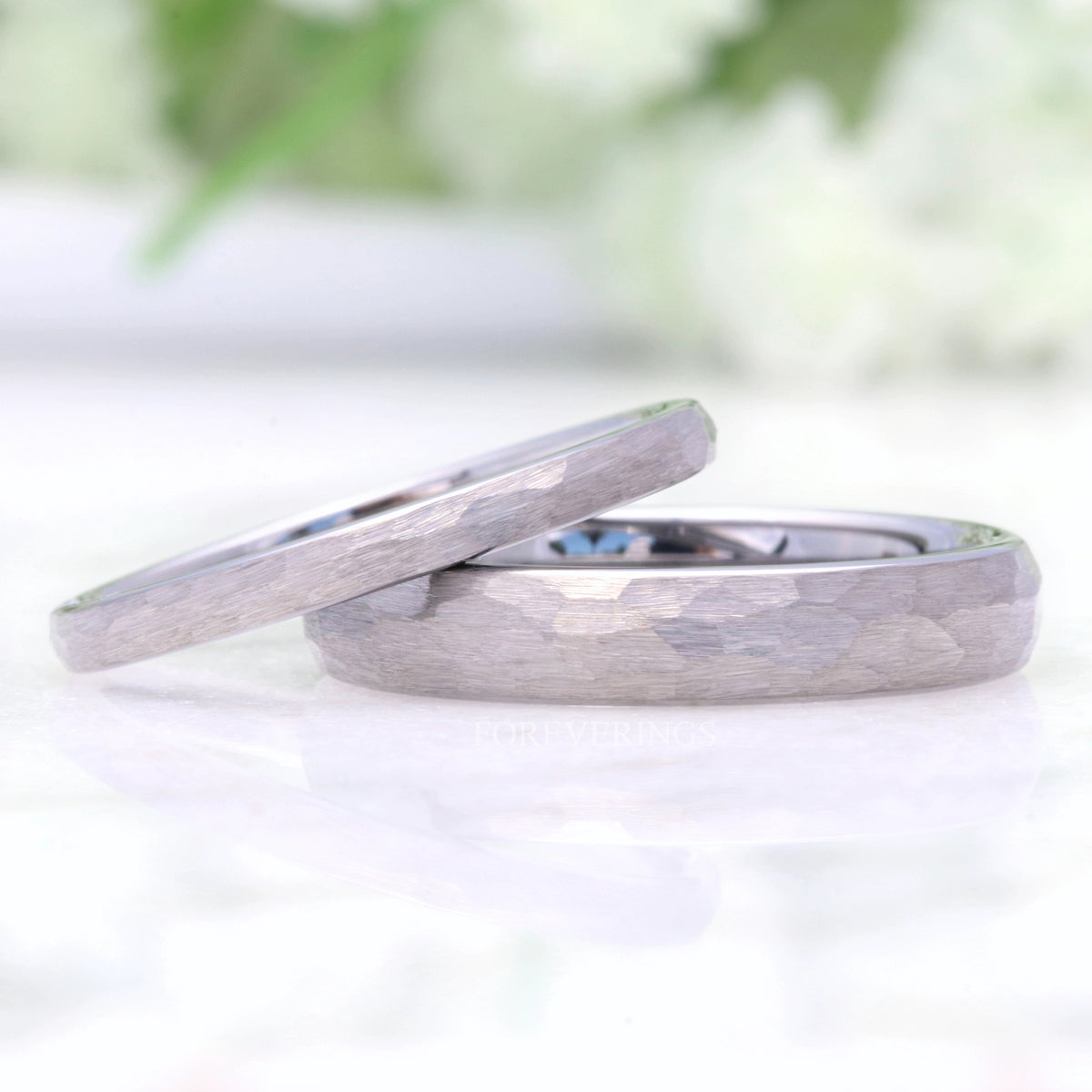 Hammered silver tungsten bands in 2mm and 4mm, the thinner one leaning on the wider