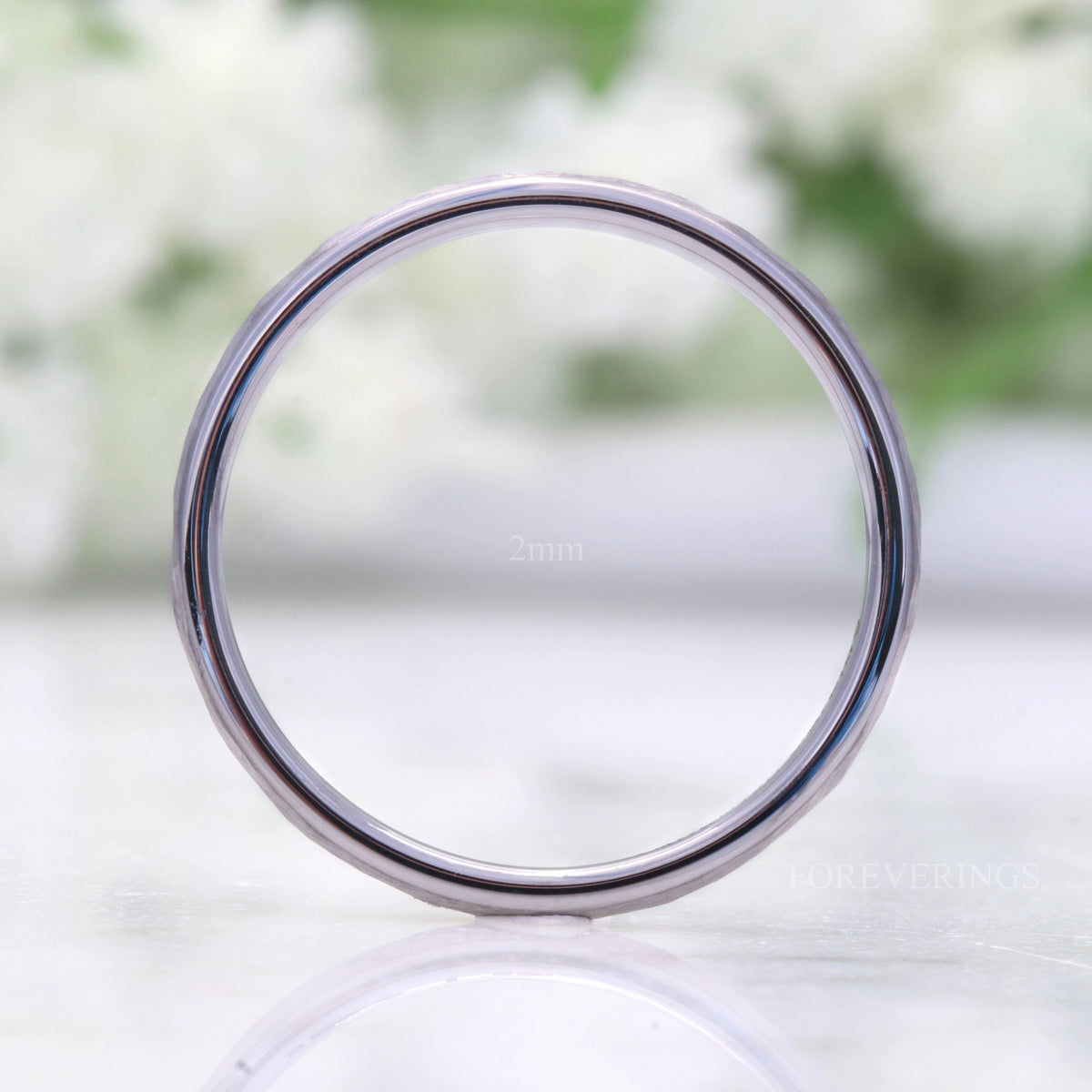 2mm hammered silver tungsten band standing upright, viewed straight through the center
