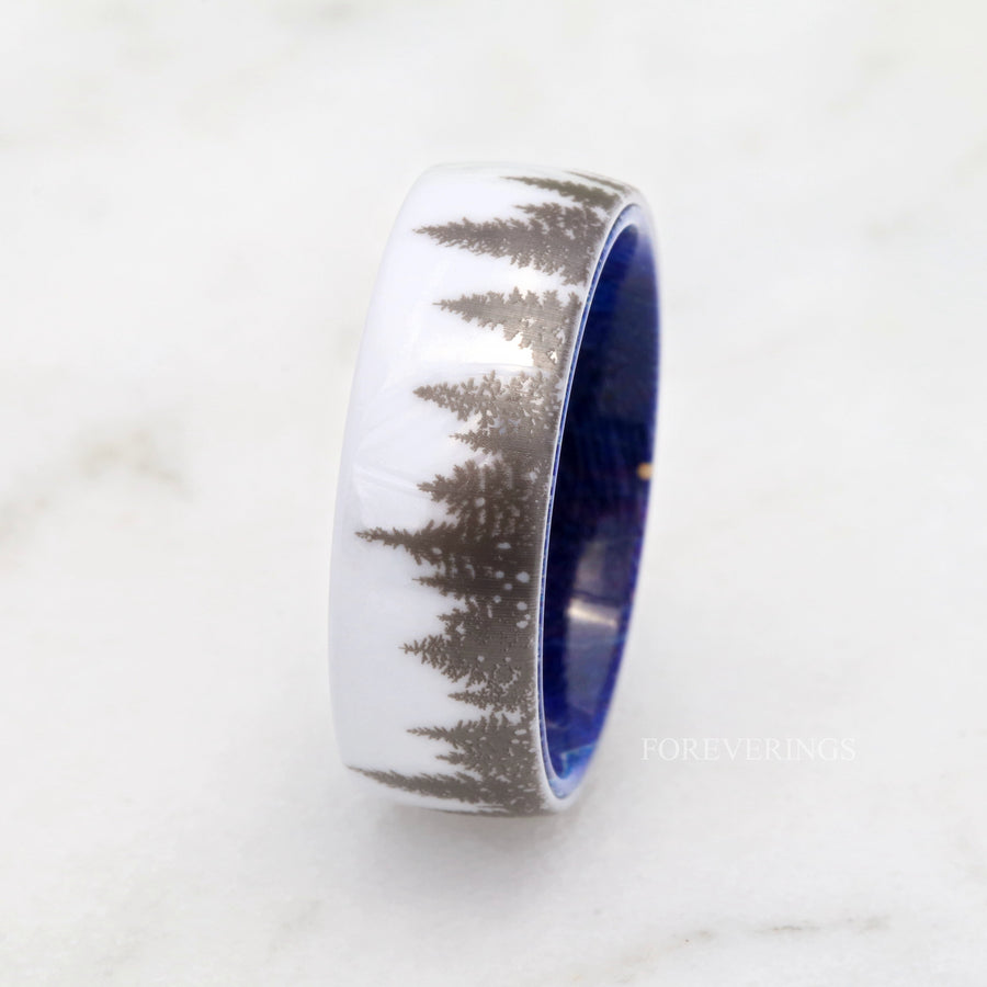 White ceramic forest band with blue wood interior on a white marble surface