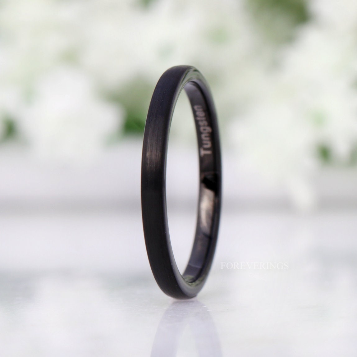 Women's 2mm black tungsten band standing upright, side angle