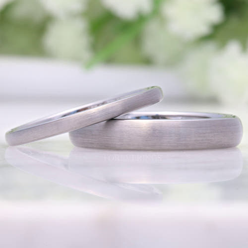2mm and 4mm brushed silver tungsten wedding bands, the thin band leaning on the wider one