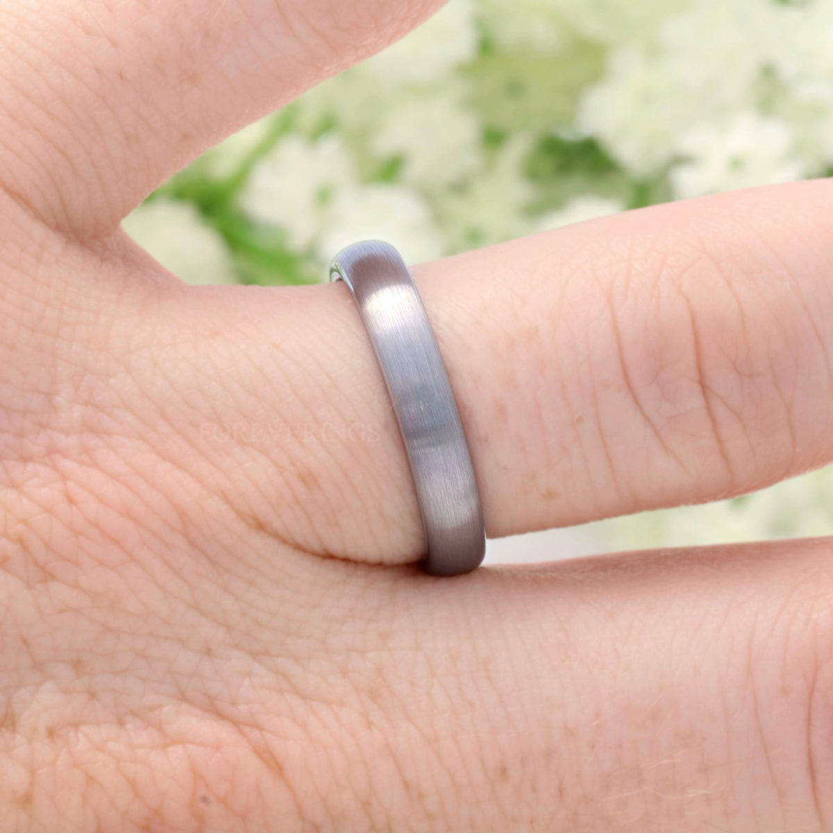 4mm brushed silver tungsten band worn on a finger, side view