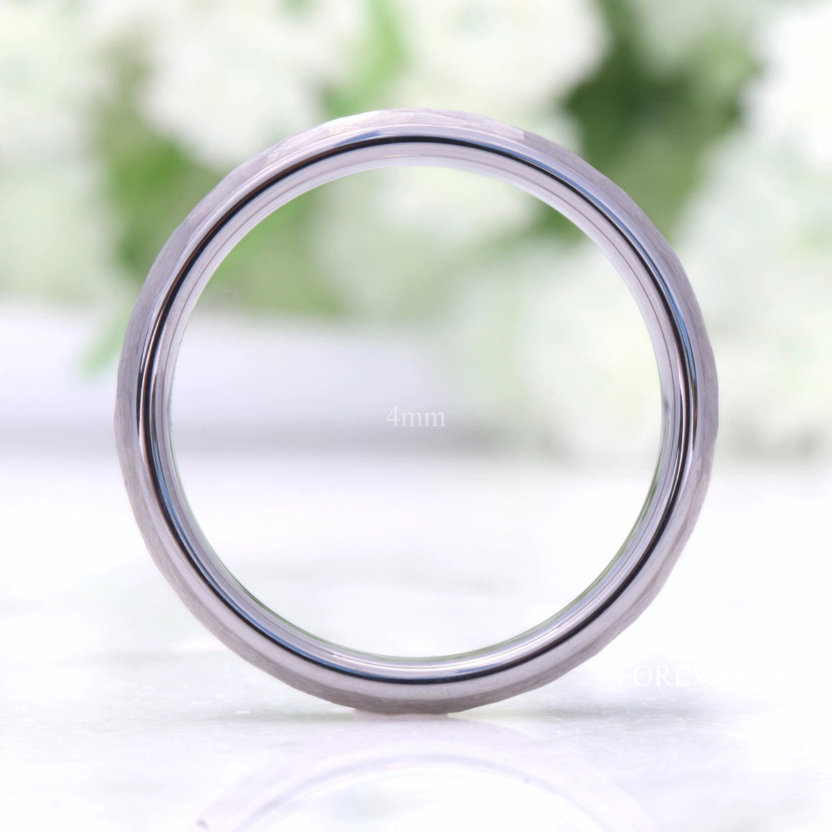 4mm hammered silver tungsten band standing upright, viewed straight through the center