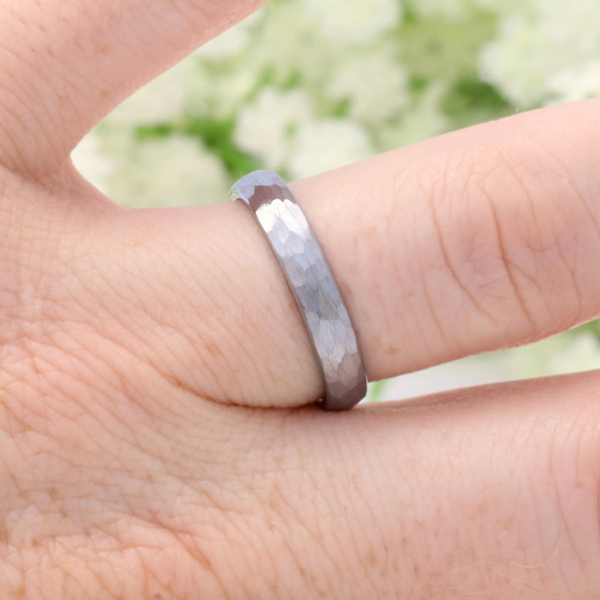 4mm hammered silver tungsten band worn on a finger
