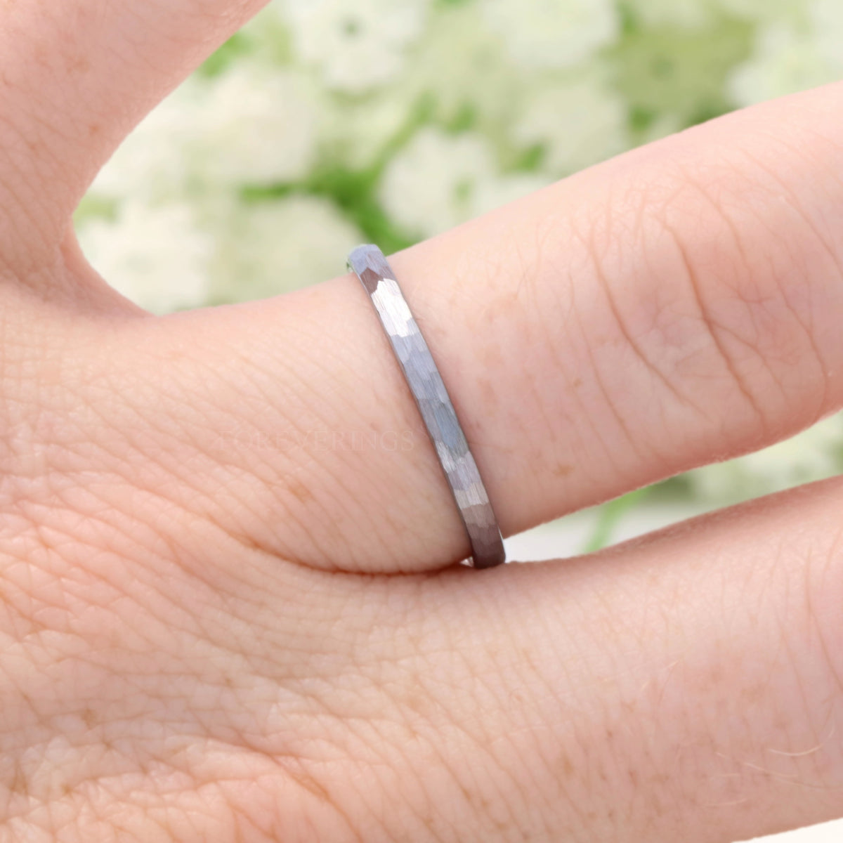 2mm hammered silver tungsten band worn on a finger