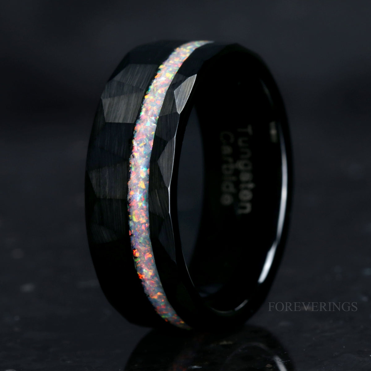 Men's 8mm black hammered tungsten band with an offset white fire opal stripe, angled