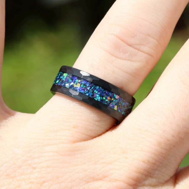 8mm hammered black tungsten galaxy opal ring worn on a finger