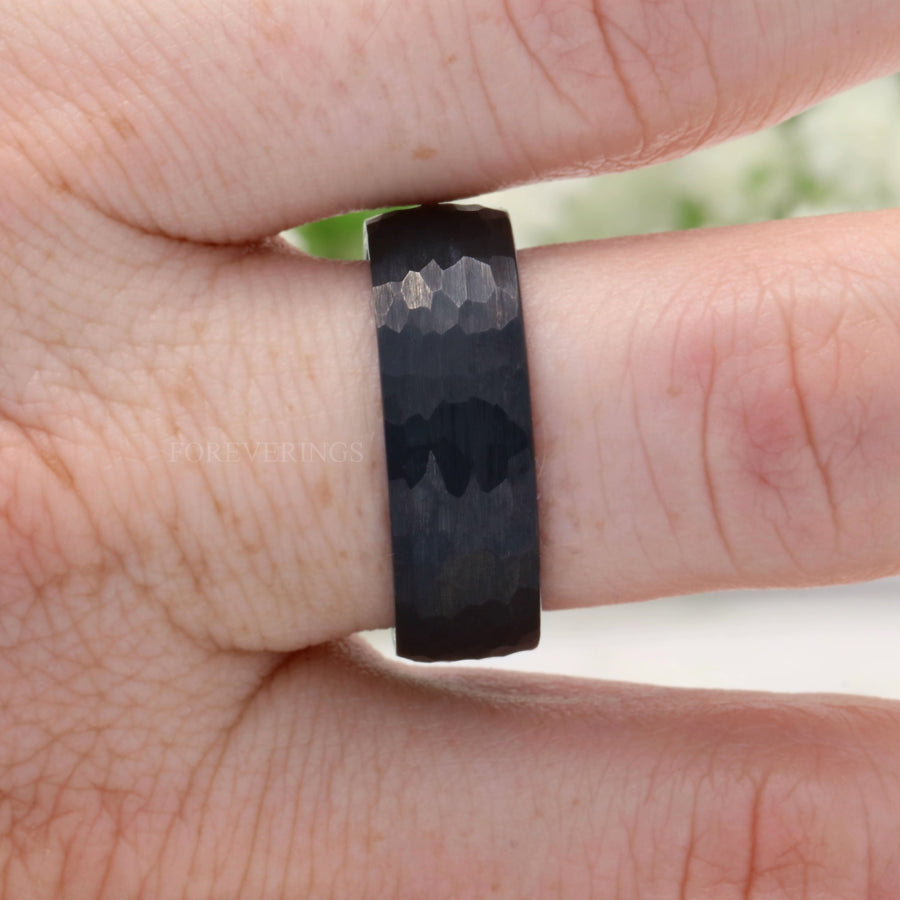8mm hammered black tungsten whiskey barrel band worn on a finger
