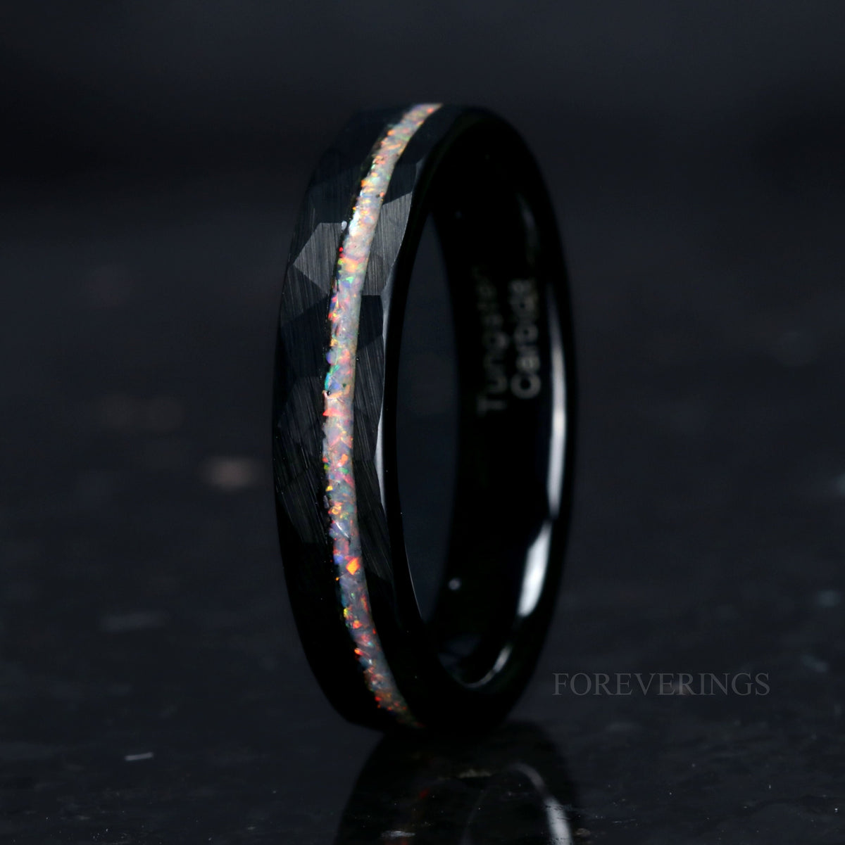 Women's 4mm black hammered tungsten ring with white fire opal inlay, standing