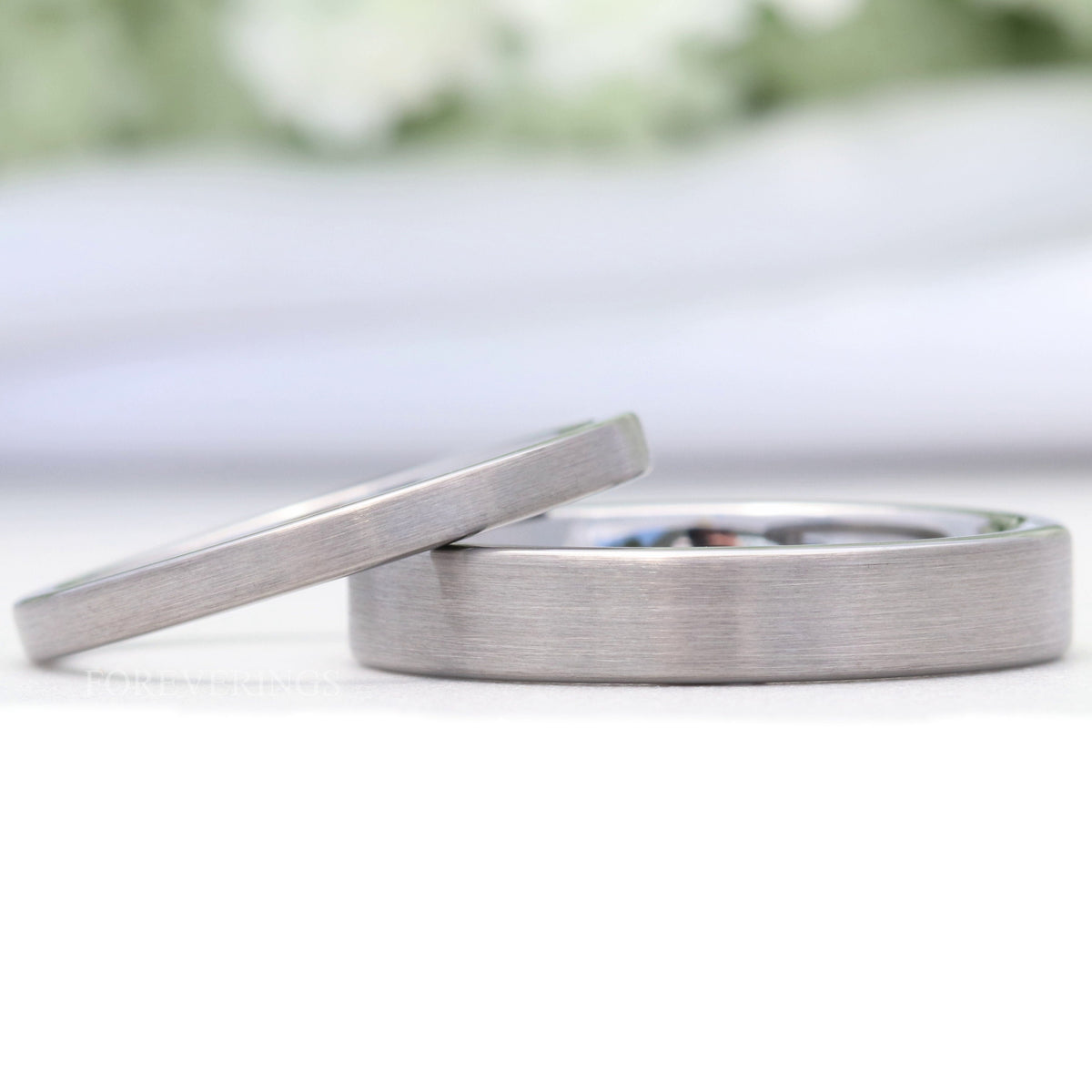 Men's and women's brushed silver tungsten wedding bands in 2mm and 4mm with a flat matte finish