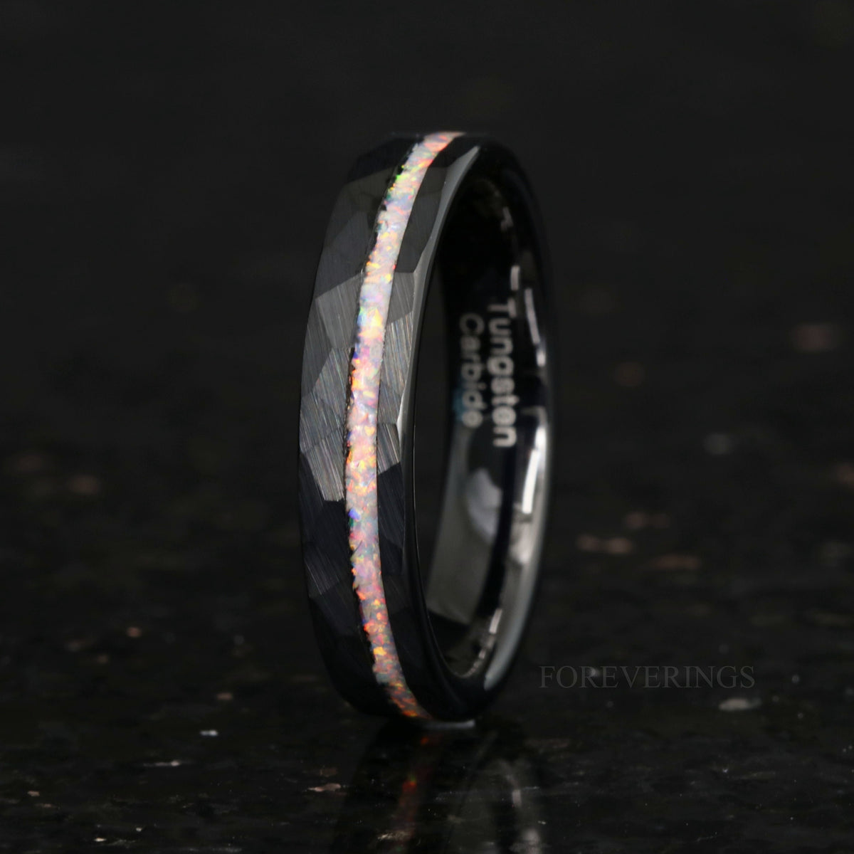 Women's 4mm hammered black tungsten ring with white fire opal inlay, standing upright