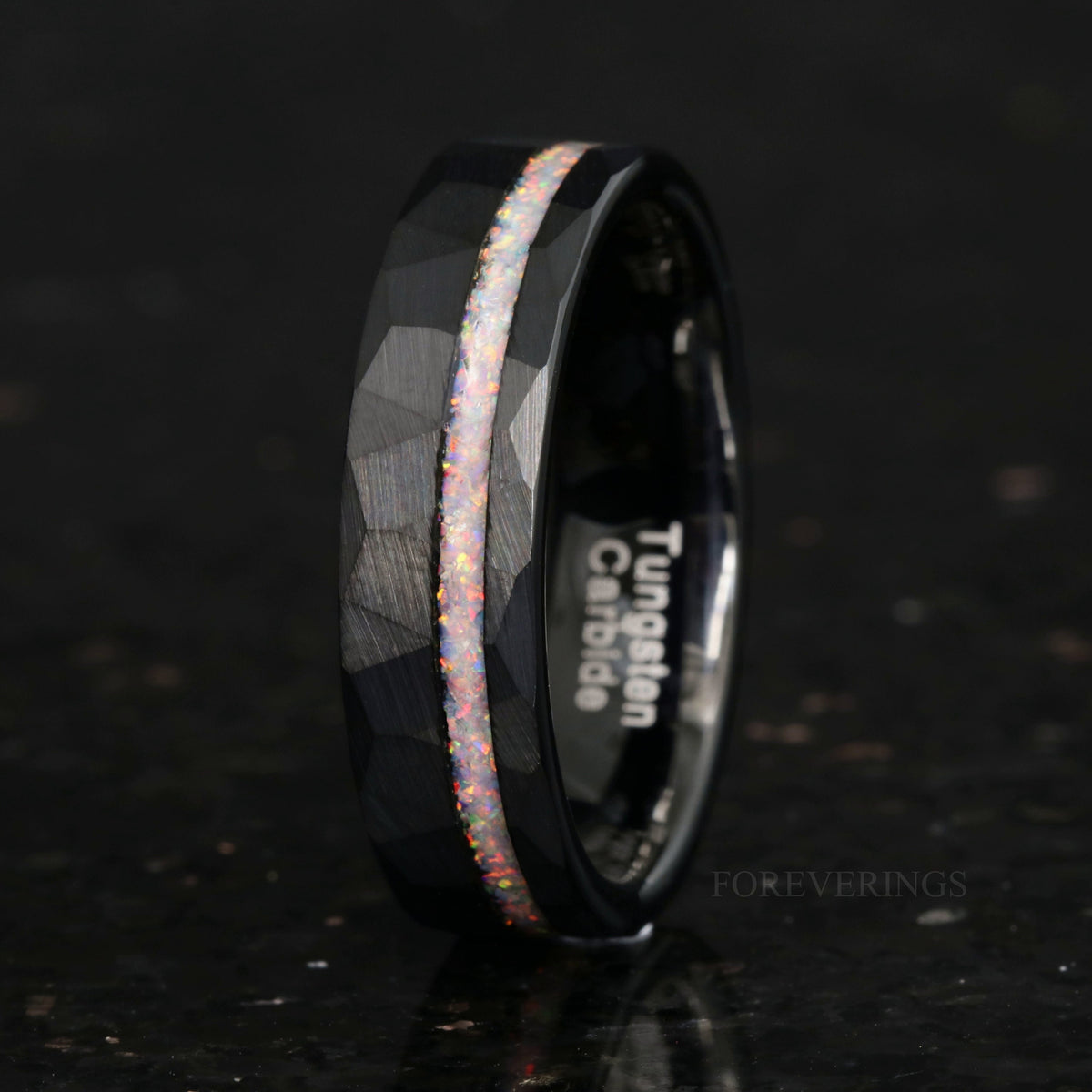 Men's 6mm hammered black tungsten ring with white fire opal inlay, angled to show the interior