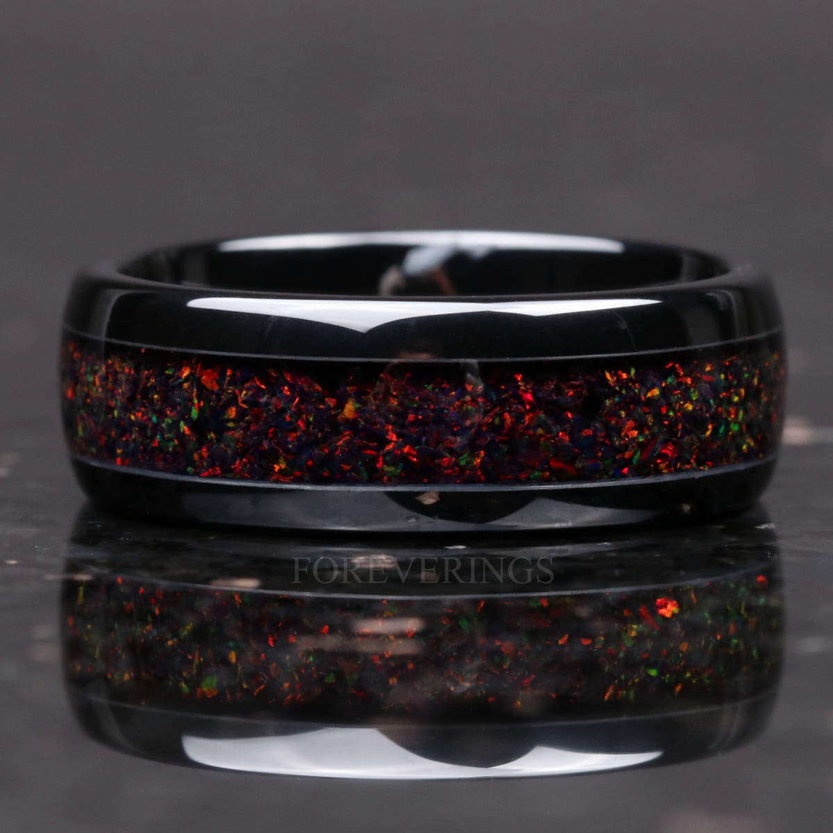 Black ceramic band with black fire opal lying flat, inlay shown straight on