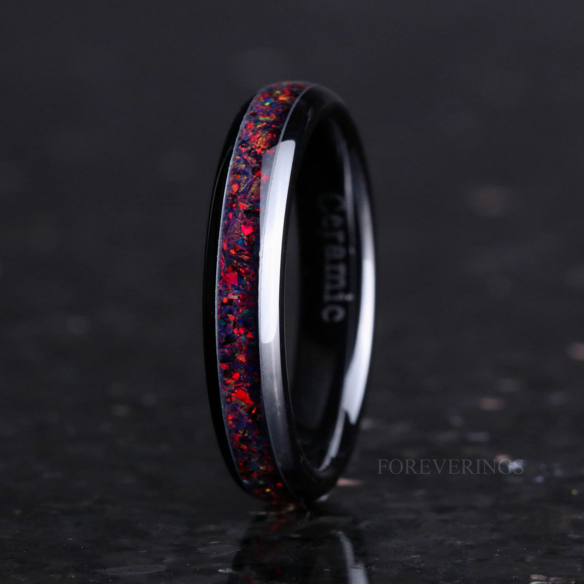 Women's 4mm black ceramic ring with black fire opal inlay standing at an angle