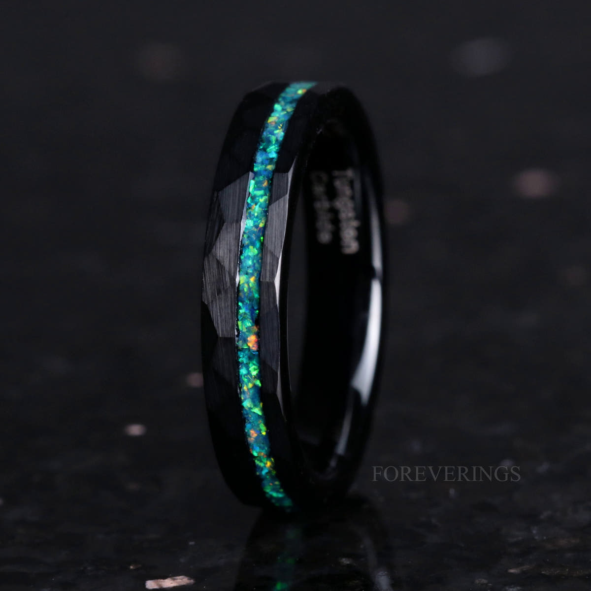 Women's 4mm hammered black tungsten ring with green opal inlay, standing upright