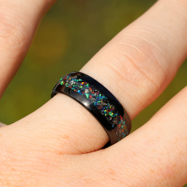 Men's 8mm black tungsten band with meteorite and galaxy opal inlay, worn on a hand