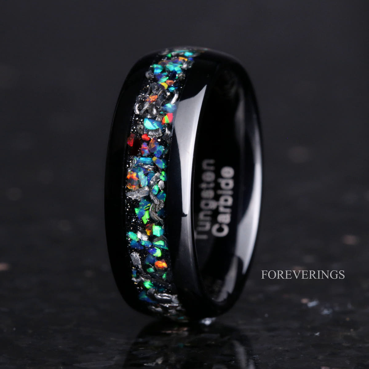 Men's 8mm polished black tungsten band with meteorite and galaxy opal inlay, standing on edge