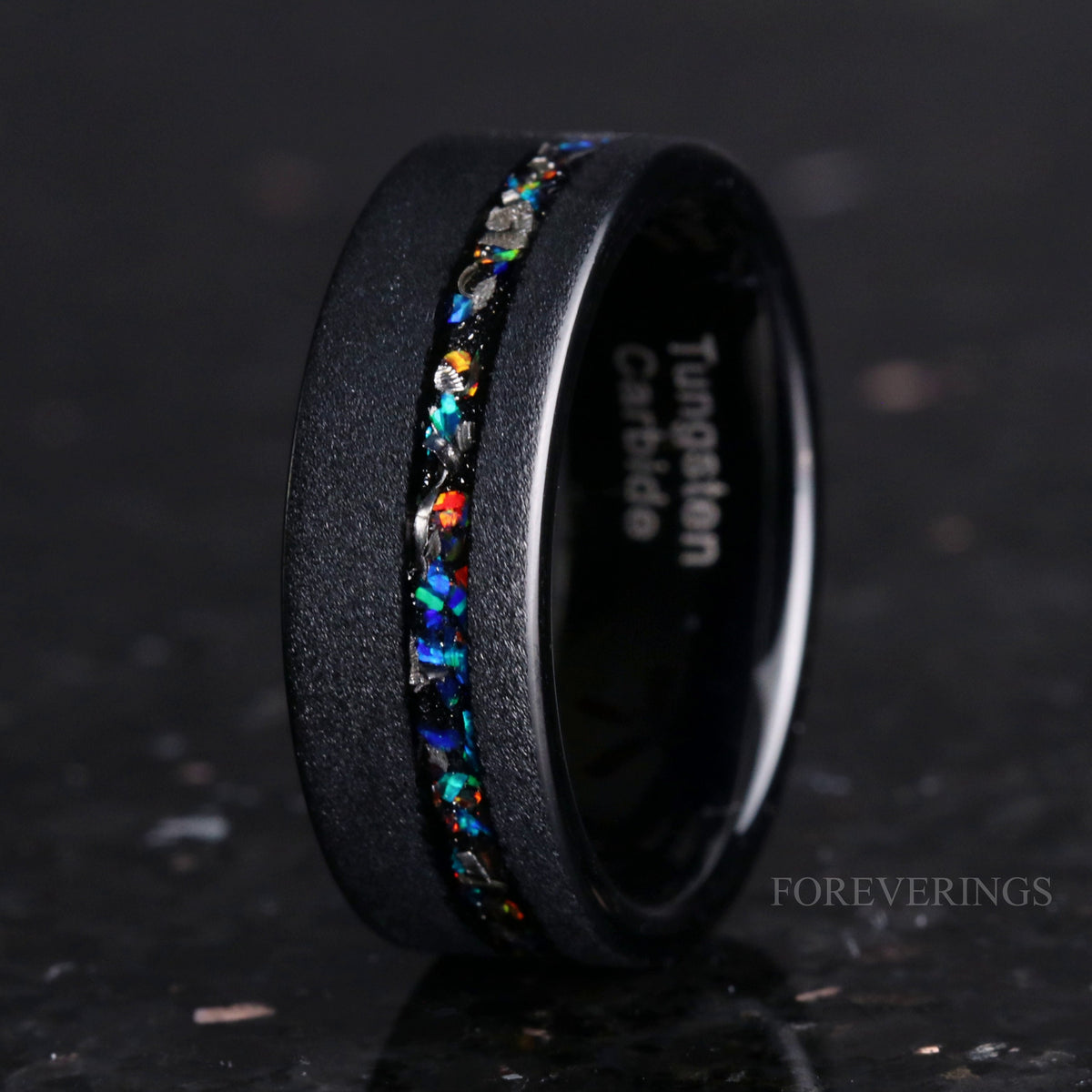 Men's 8mm sandblasted black tungsten band standing at an angle, meteorite and galaxy opal channel