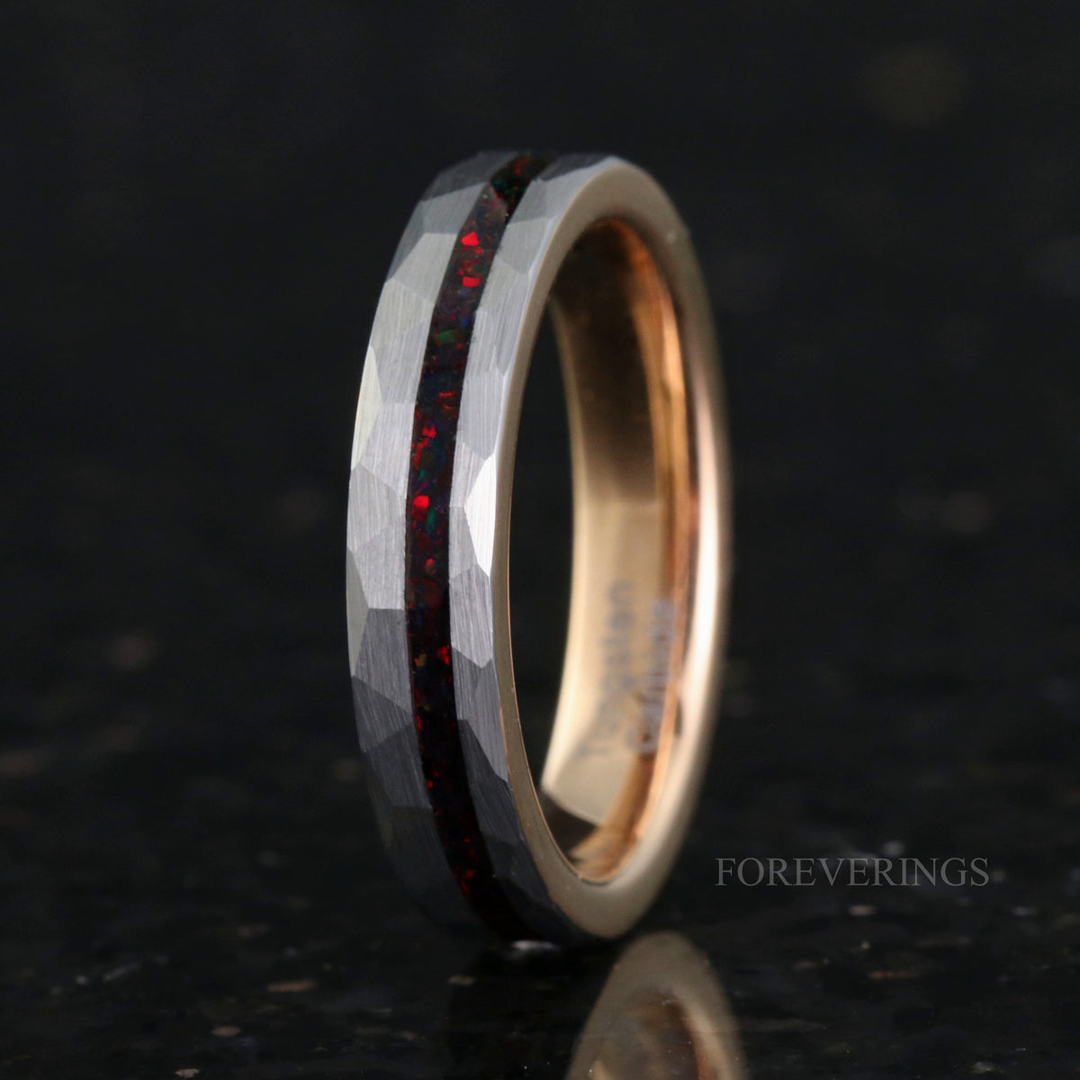 Women's 4mm hammered silver tungsten ring with black fire opal inlay, rose gold inside, standing on edge