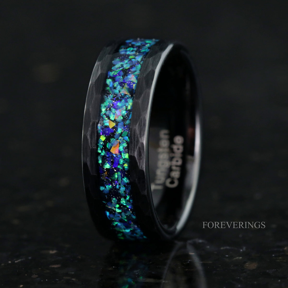 Men's 8mm hammered black tungsten band with galaxy opal inlay, standing to show the interior