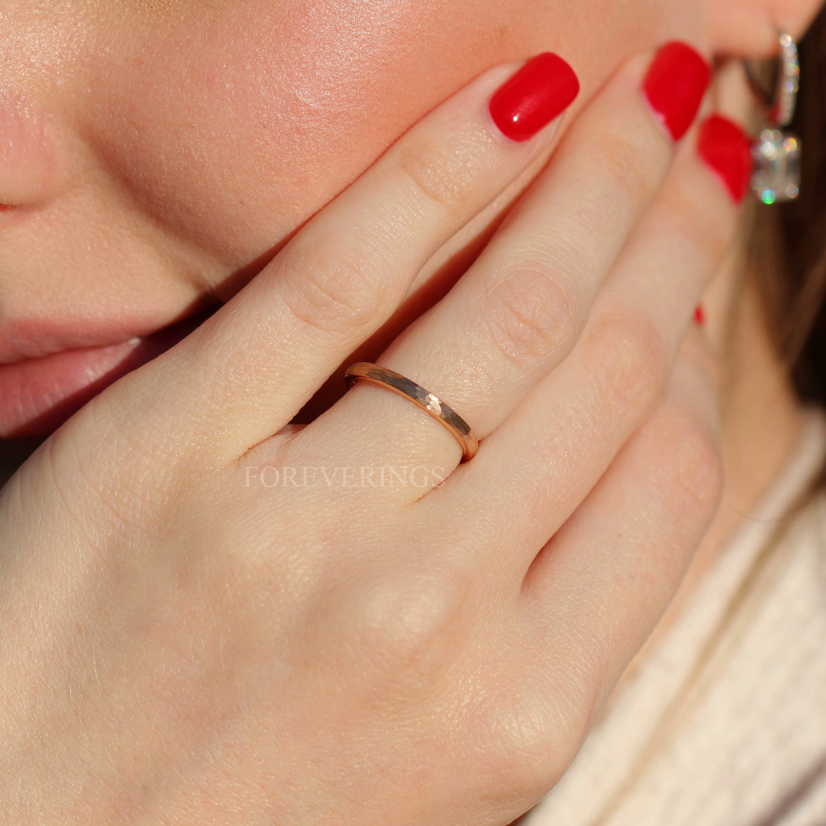 2mm hammered rose gold tungsten ring worn on a hand, wider view