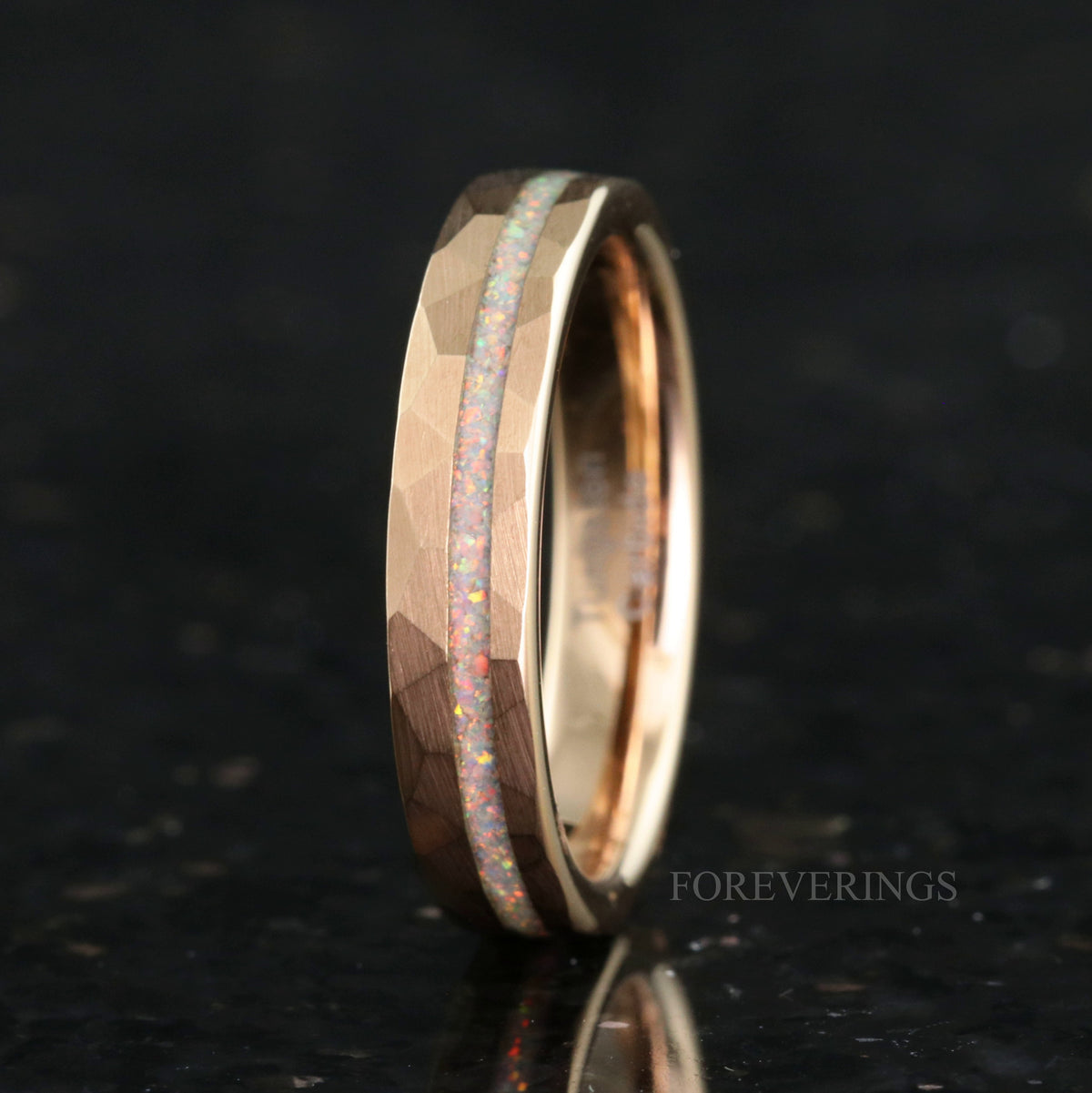 Women's 4mm hammered rose gold tungsten ring with a white fire opal stripe, standing upright