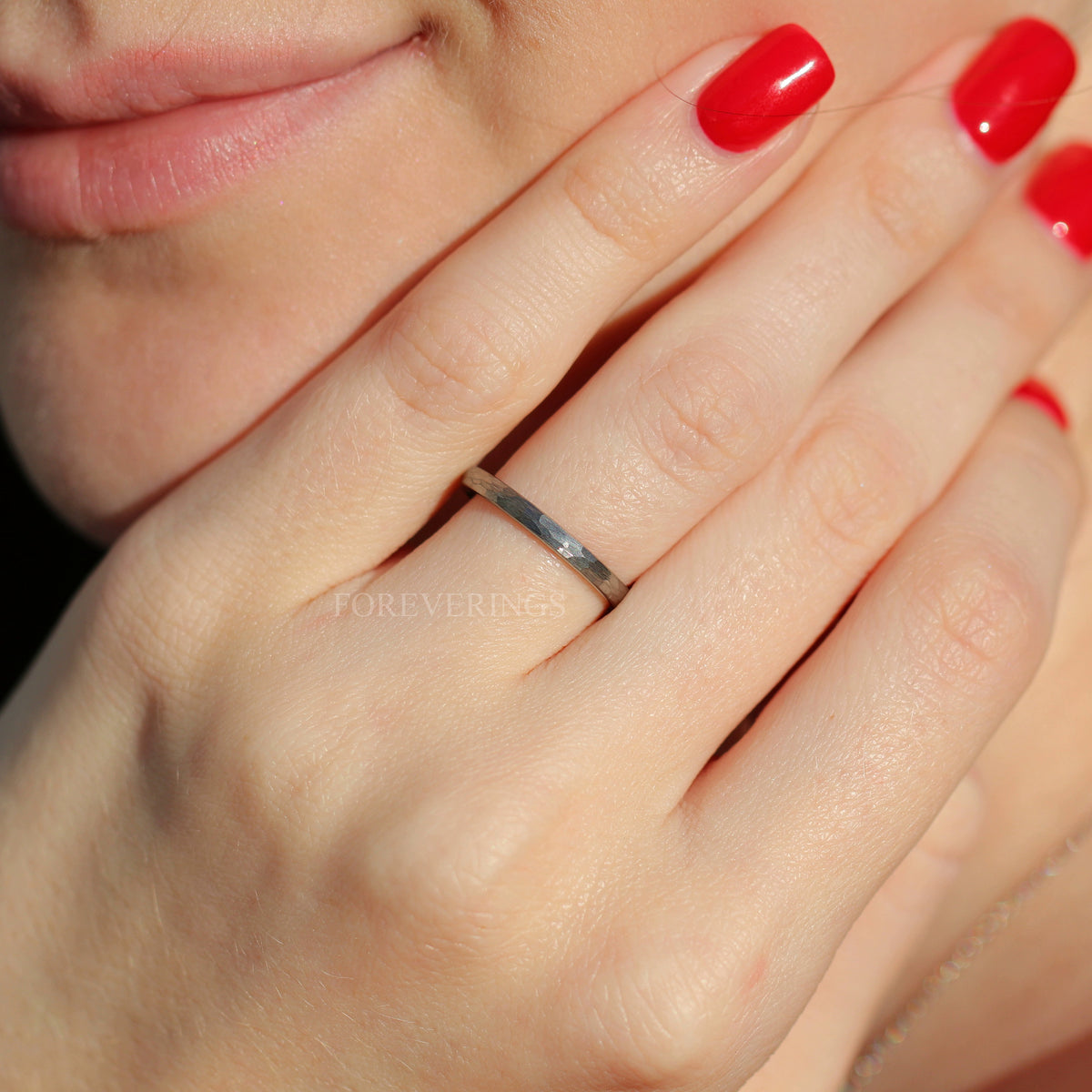 Woman wearing a 2mm hammered silver tungsten band on her ring finger
